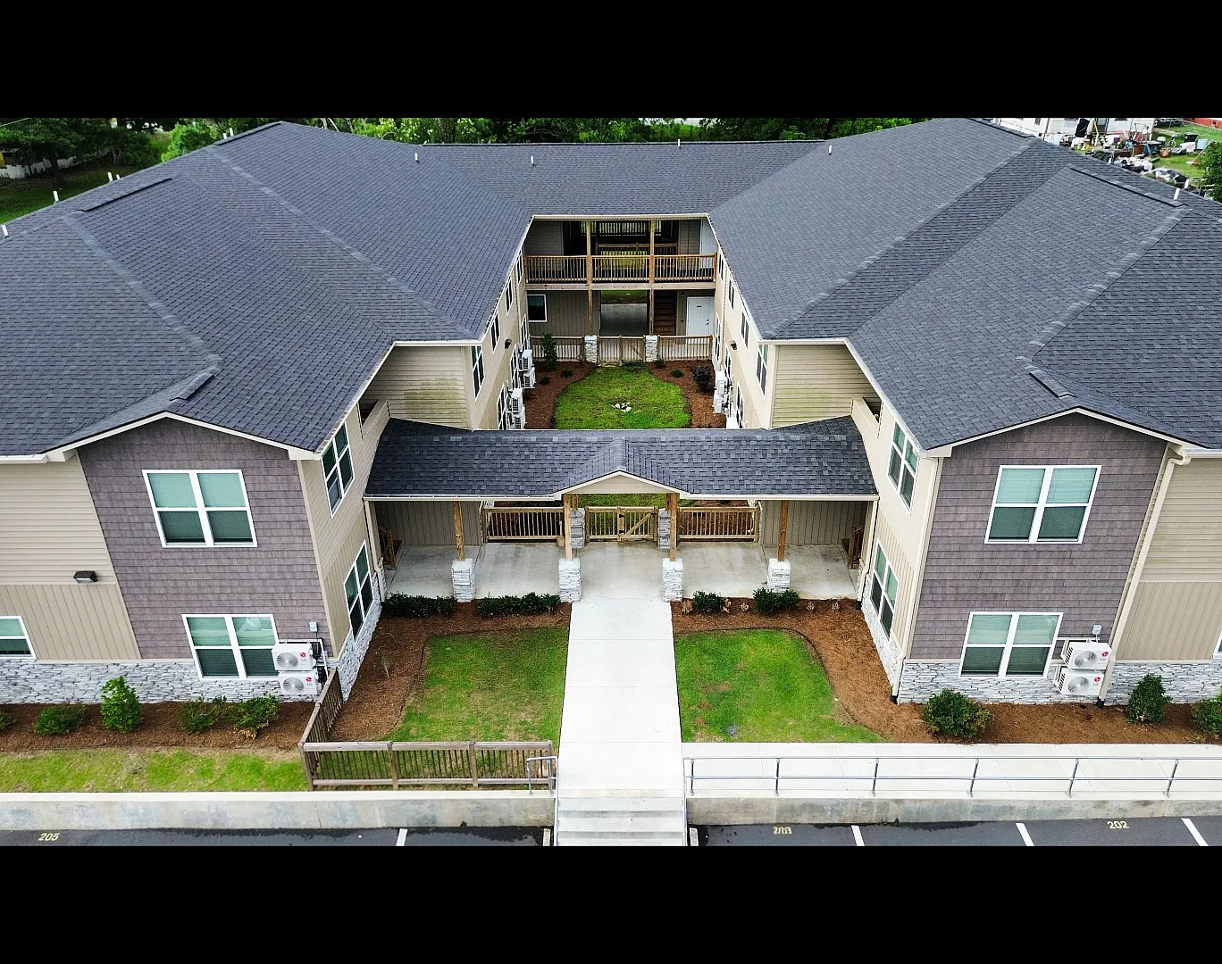Modern apartment complex with a well-maintained courtyard, featuring a stylish architectural design and spacious layout.