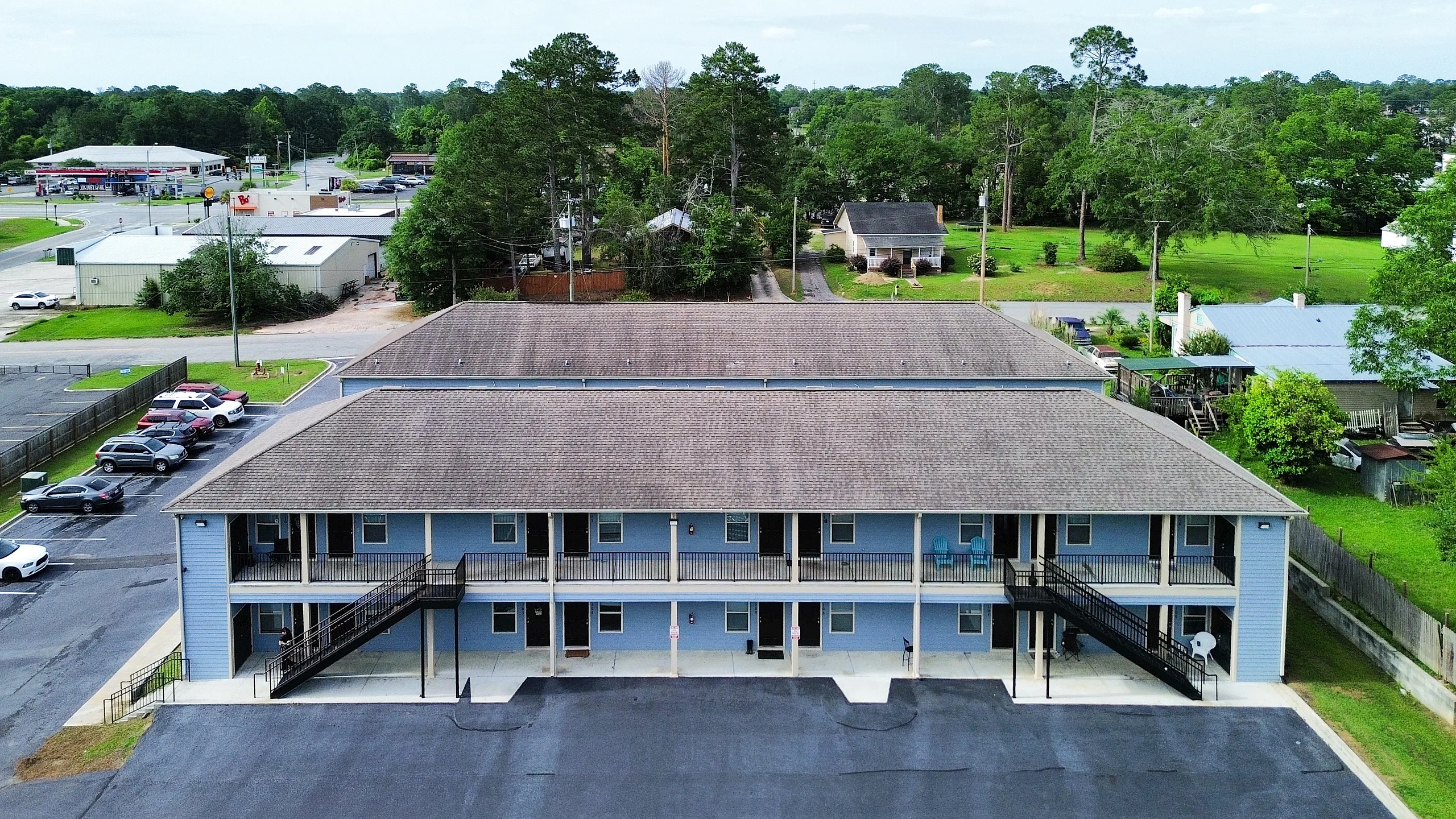 Inviting two-story apartment complex with charming exterior and ample parking, nestled in a lush green suburban neighborhood.