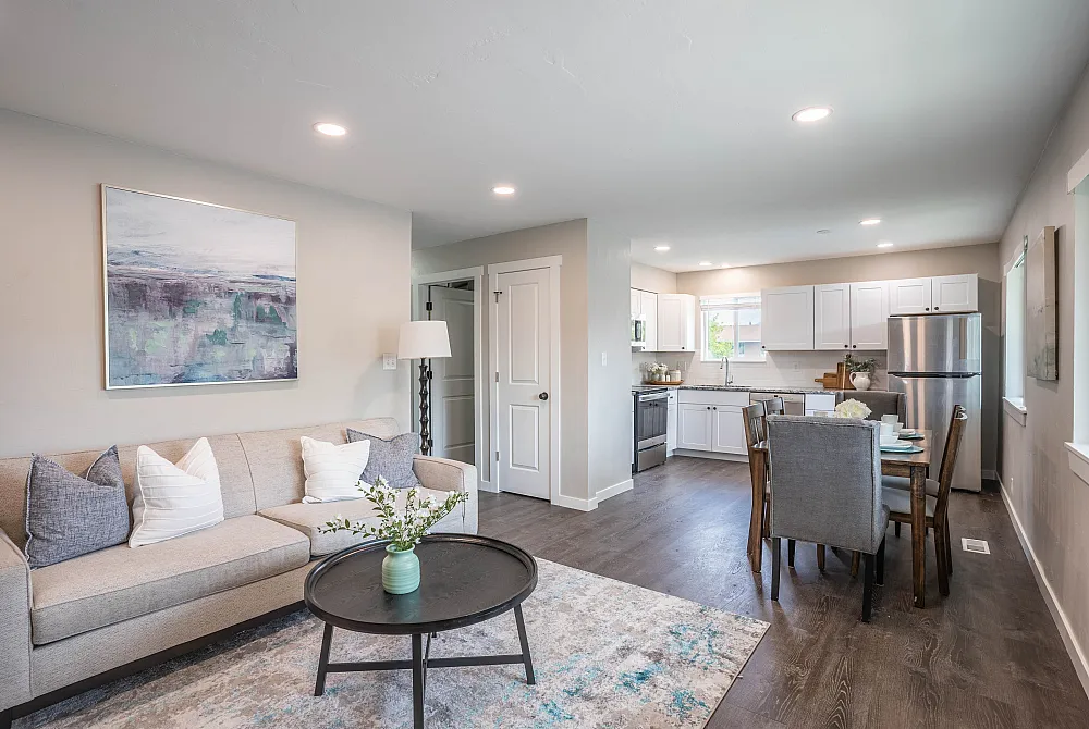 Inviting open-concept living area with modern kitchen, cozy seating, and stylish decor in a bright apartment setting.