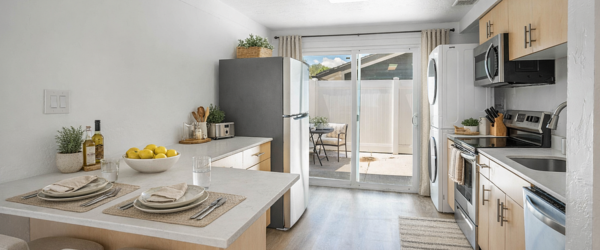 Bright, modern kitchen with sleek appliances, cozy breakfast bar, and inviting patio access.