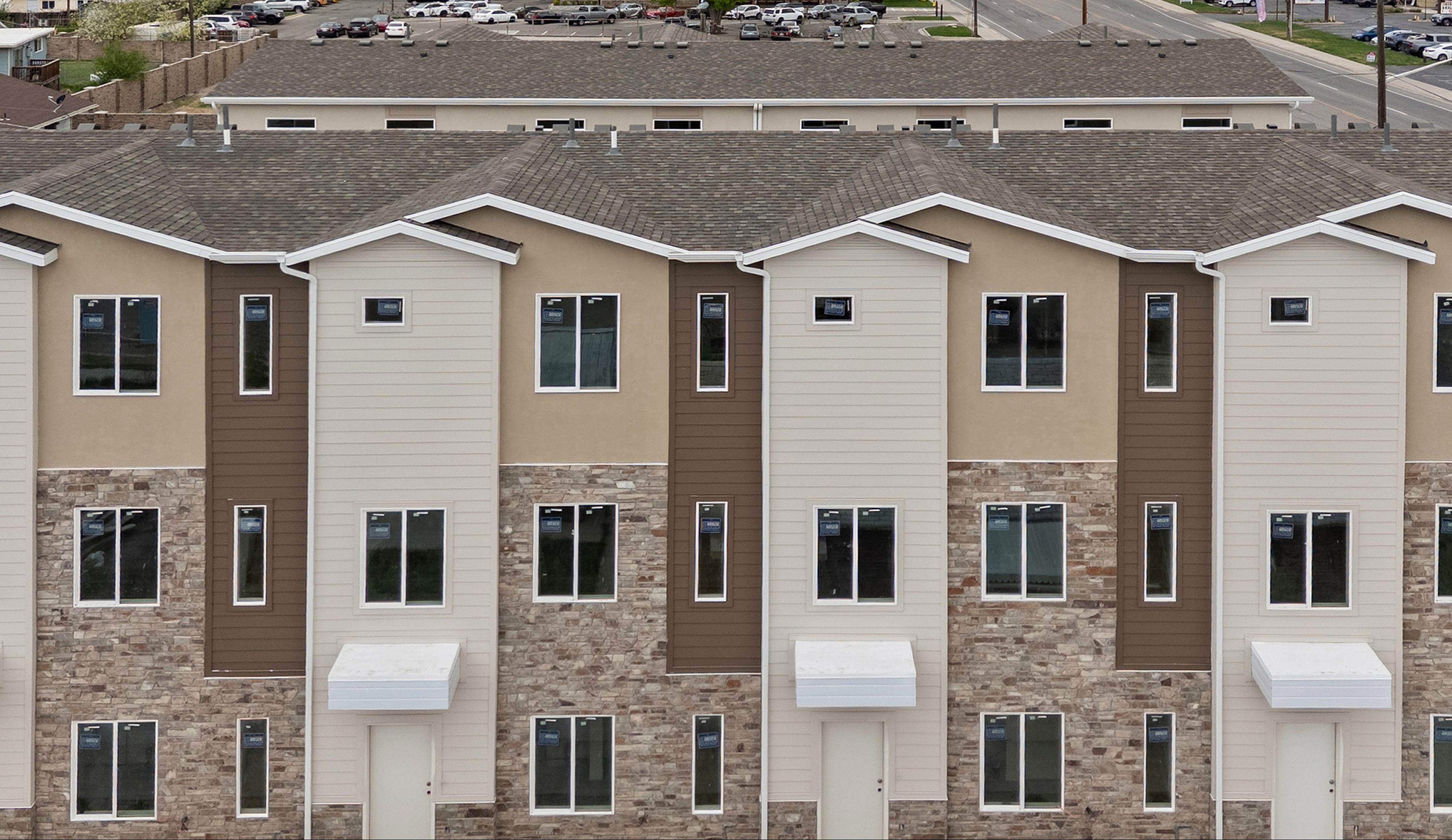 Modern apartment building with multiple stories and fresh siding, set against a scenic mountain backdrop.