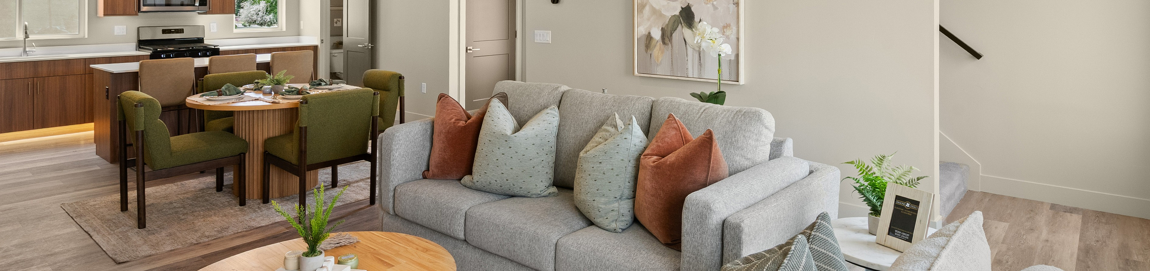 Modern open-concept living and dining area showcasing elegant furnishings and a sleek kitchen design.