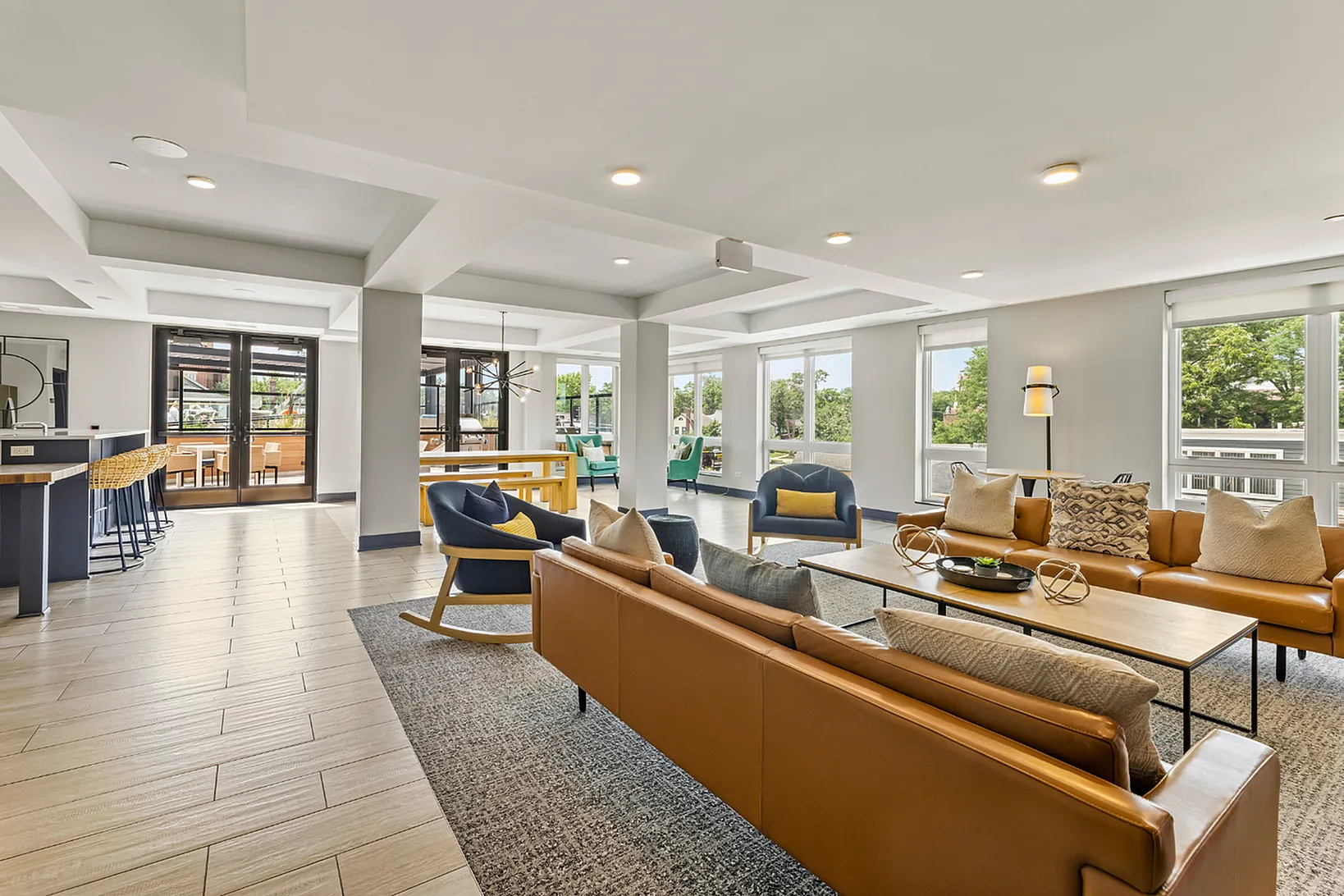 Modern and inviting open-concept community lounge featuring stylish seating, large windows, and chic decor, perfect for social gatherings and relaxation.
