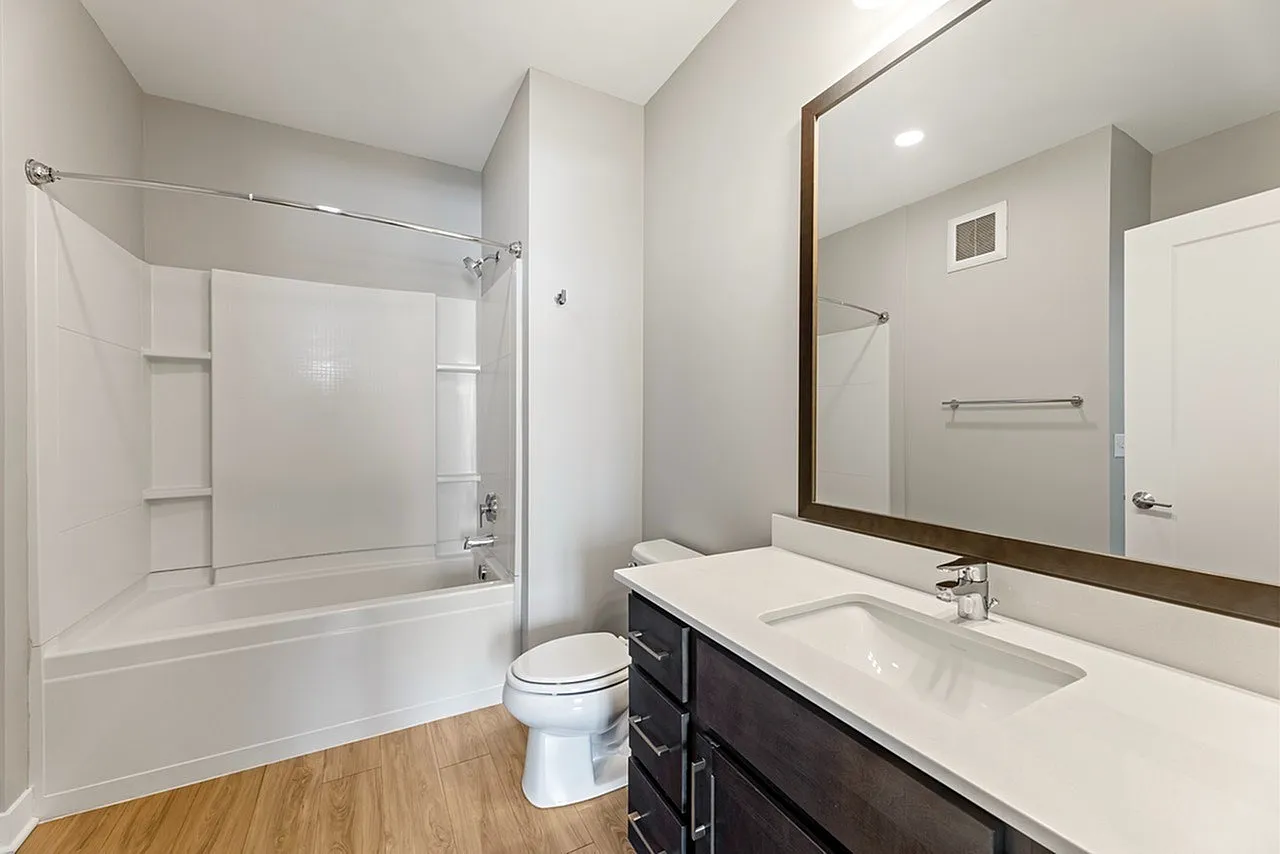 Modern bathroom with elegant fixtures, spacious bathtub, and sleek vanity, beautifully designed for comfort and style.