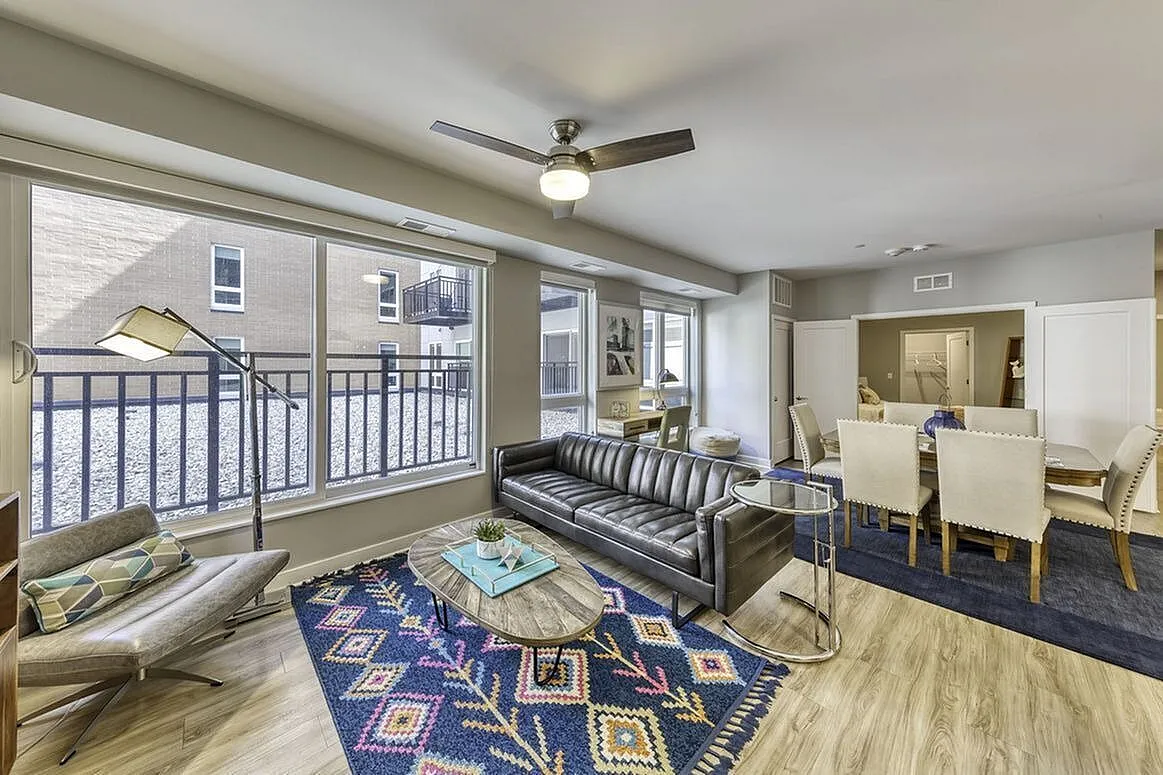 Contemporary living and dining area featuring elegant furniture, chic decor, and abundant natural light through large windows.