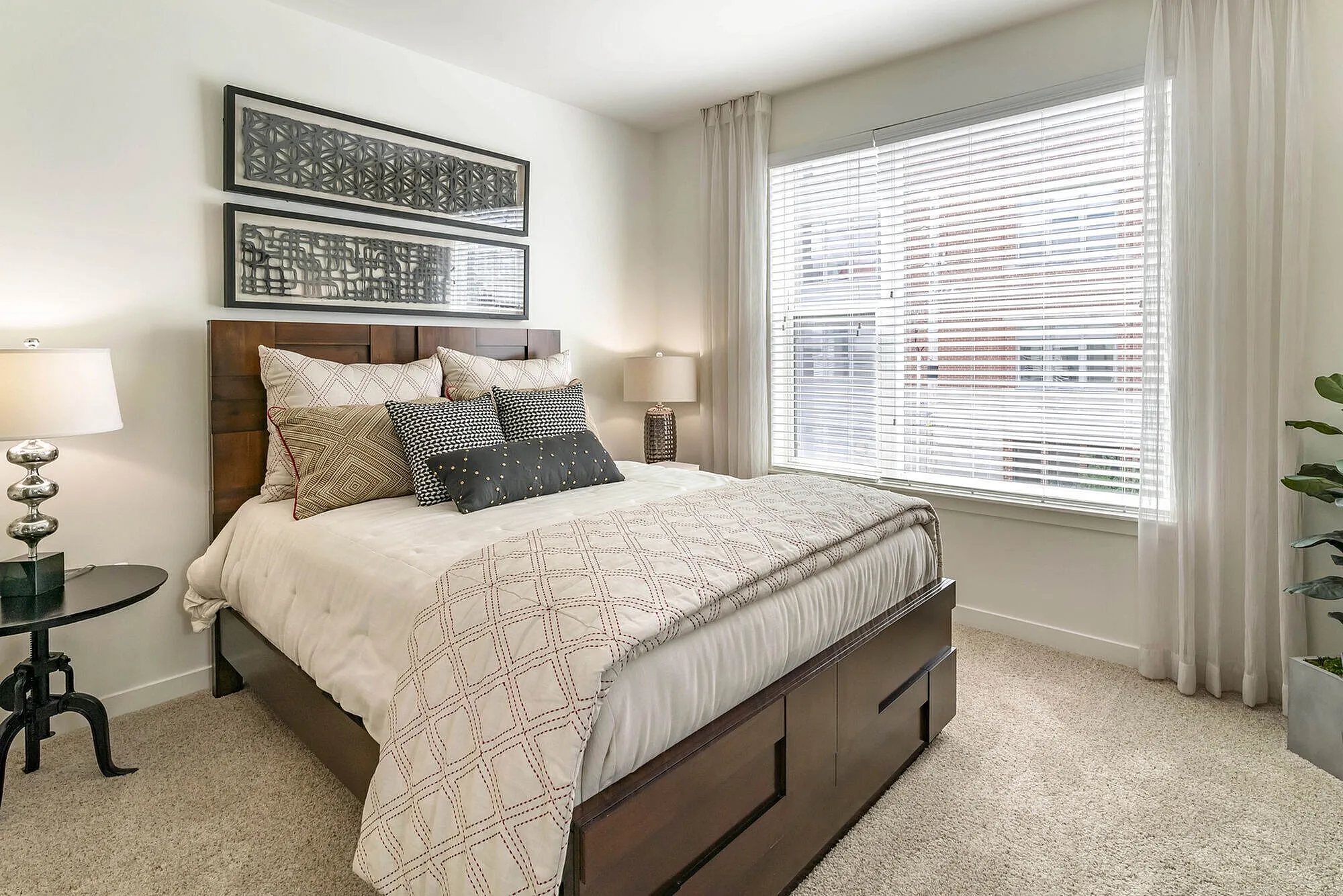 Cozy bedroom with elegant decor, featuring a plush bed and abundant natural light from large windows.