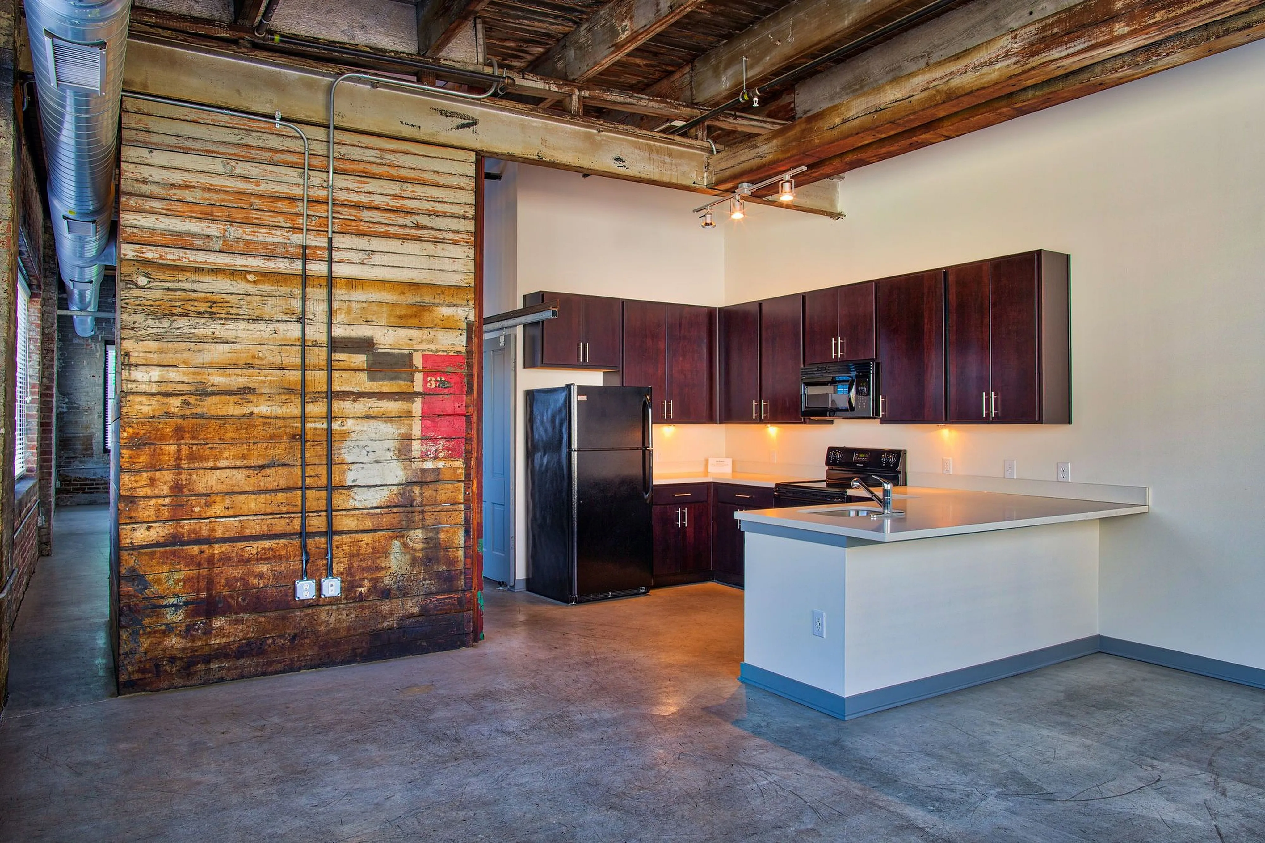 Chic industrial-style kitchen with exposed beams, rustic wood accents, and sleek modern cabinetry.