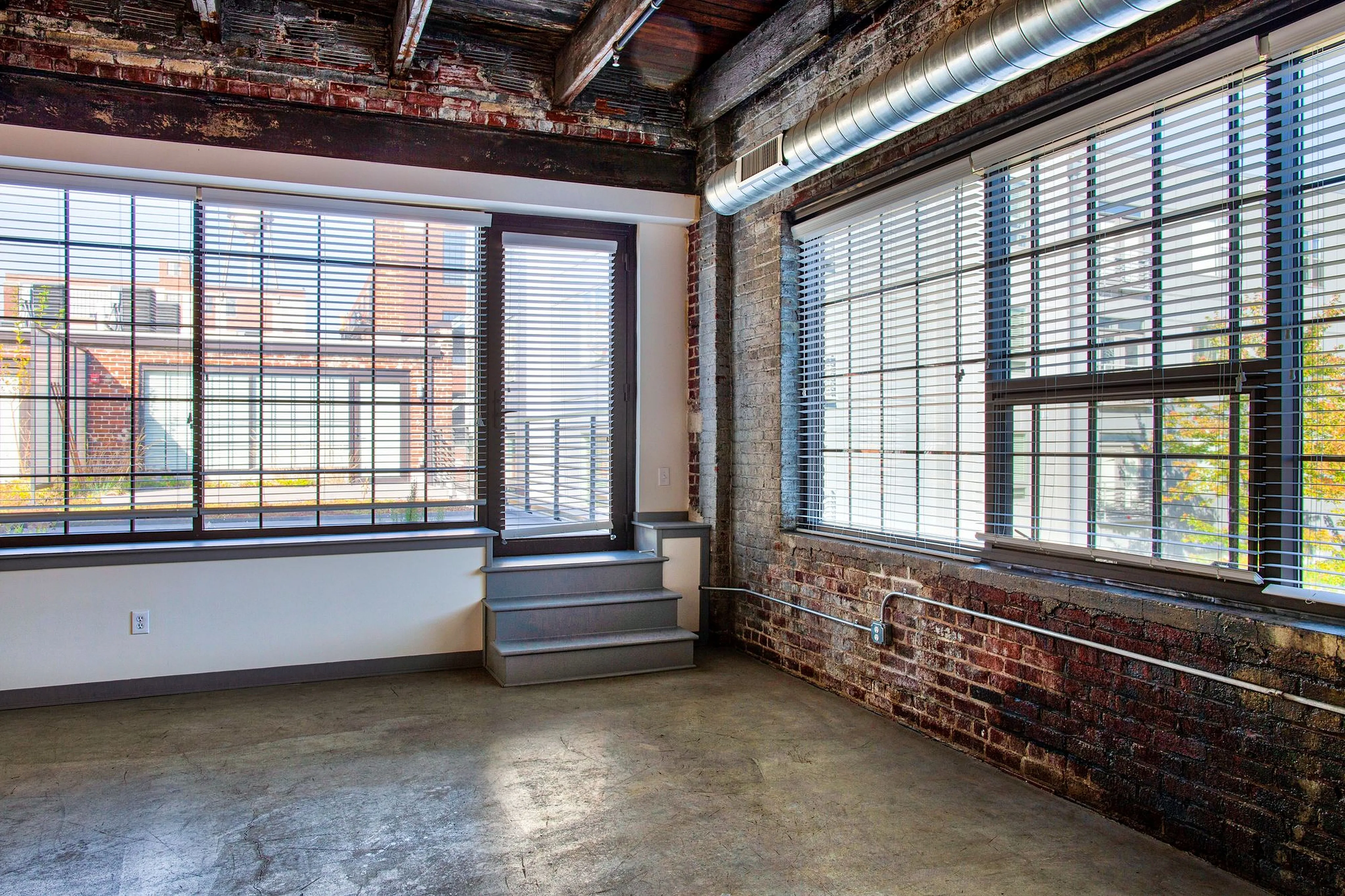 Chic urban loft with large windows, exposed brick walls, and industrial ceiling for a modern city vibe.