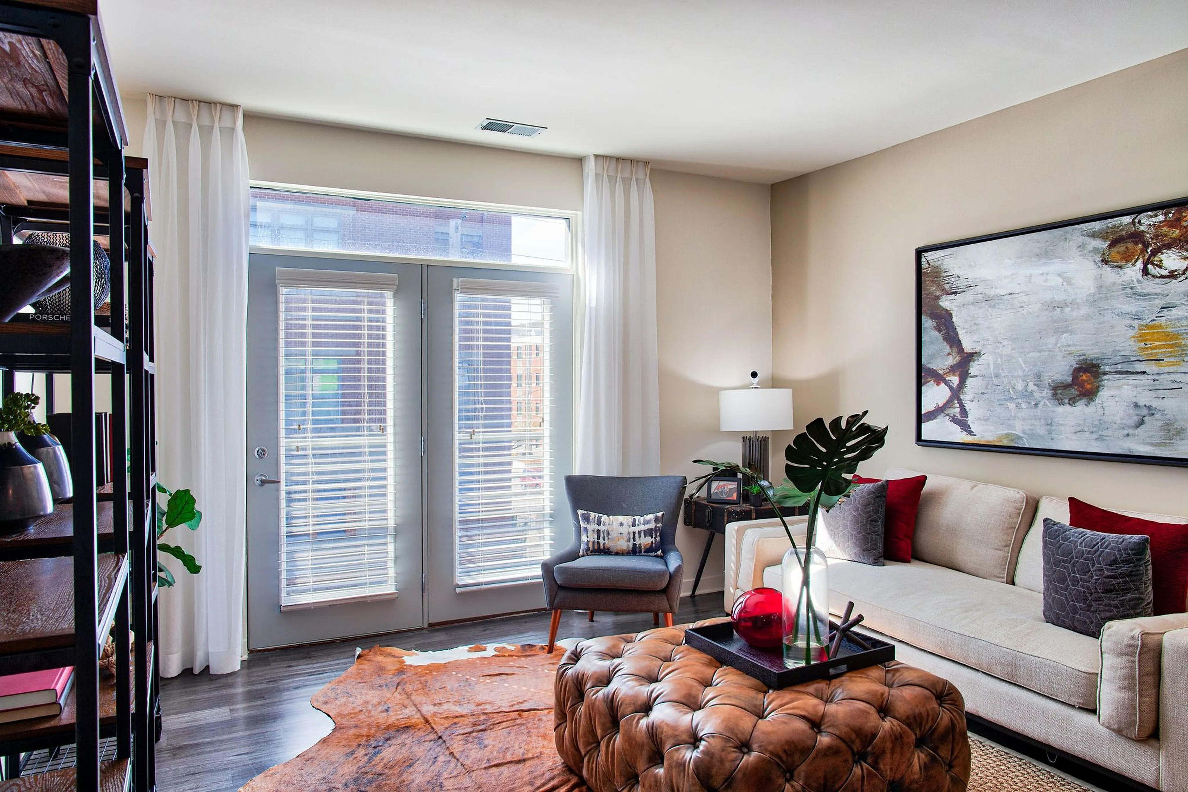 Bright and inviting living room with stylish decor, featuring a cozy sofa, chic armchair, and a contemporary art piece.