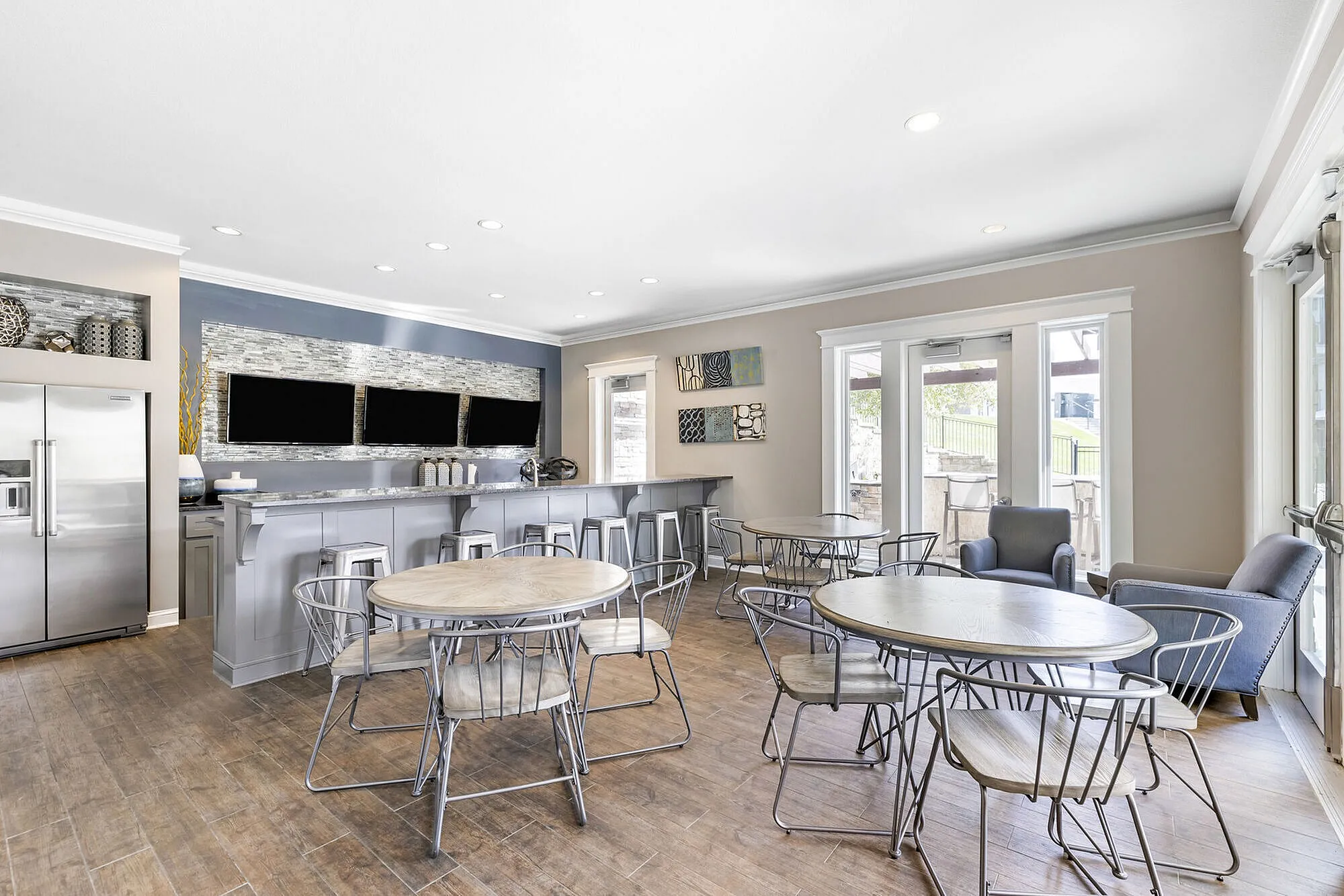 Chic communal lounge with modern furnishings, sleek bar area, and bright natural lighting, perfect for social gatherings and relaxation.