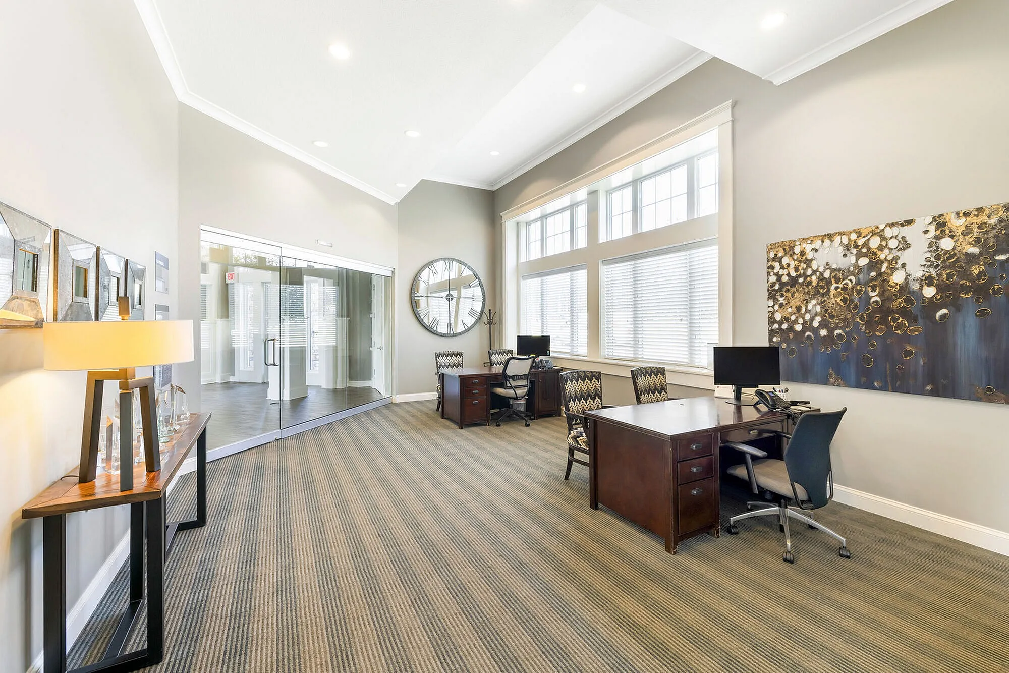 Elegant leasing office with modern decor, featuring large windows, stylish desks, and contemporary artwork.