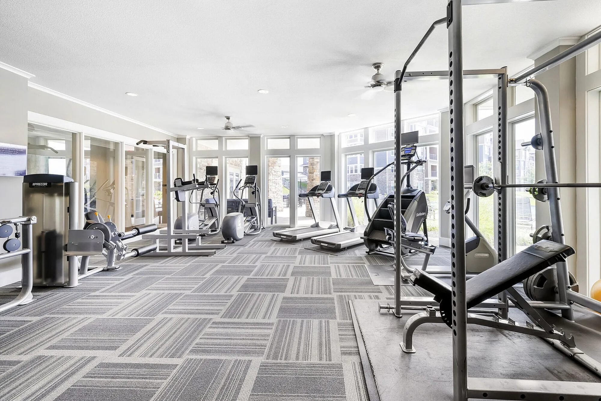 Bright and modern fitness center equipped with state-of-the-art gym equipment and large windows for natural light.