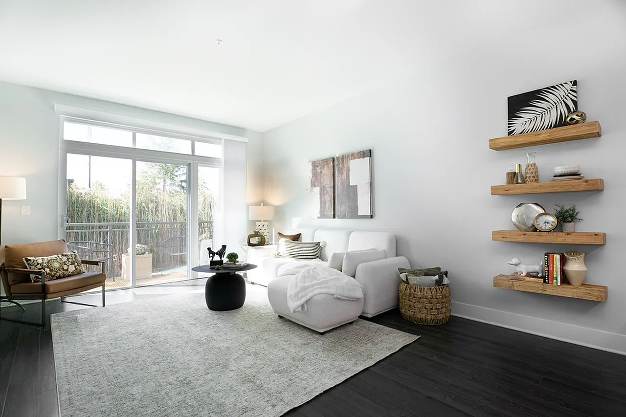 Elegant living room with modern white sofa, stylish decor on wooden shelves, and large windows offering a bright airy feel.