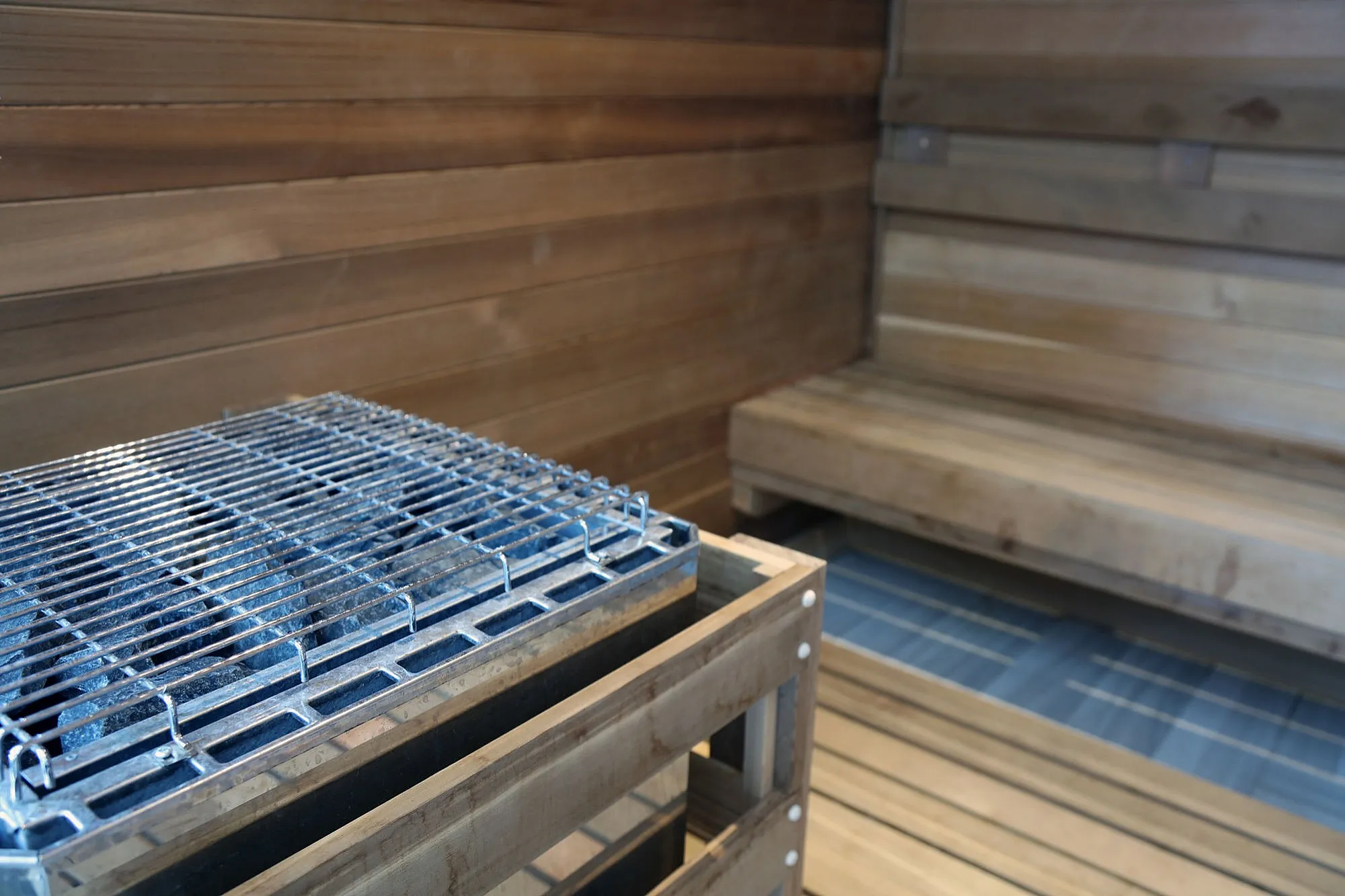 Luxurious wooden sauna with sleek heating unit and spacious seating, perfect for relaxation and rejuvenation.