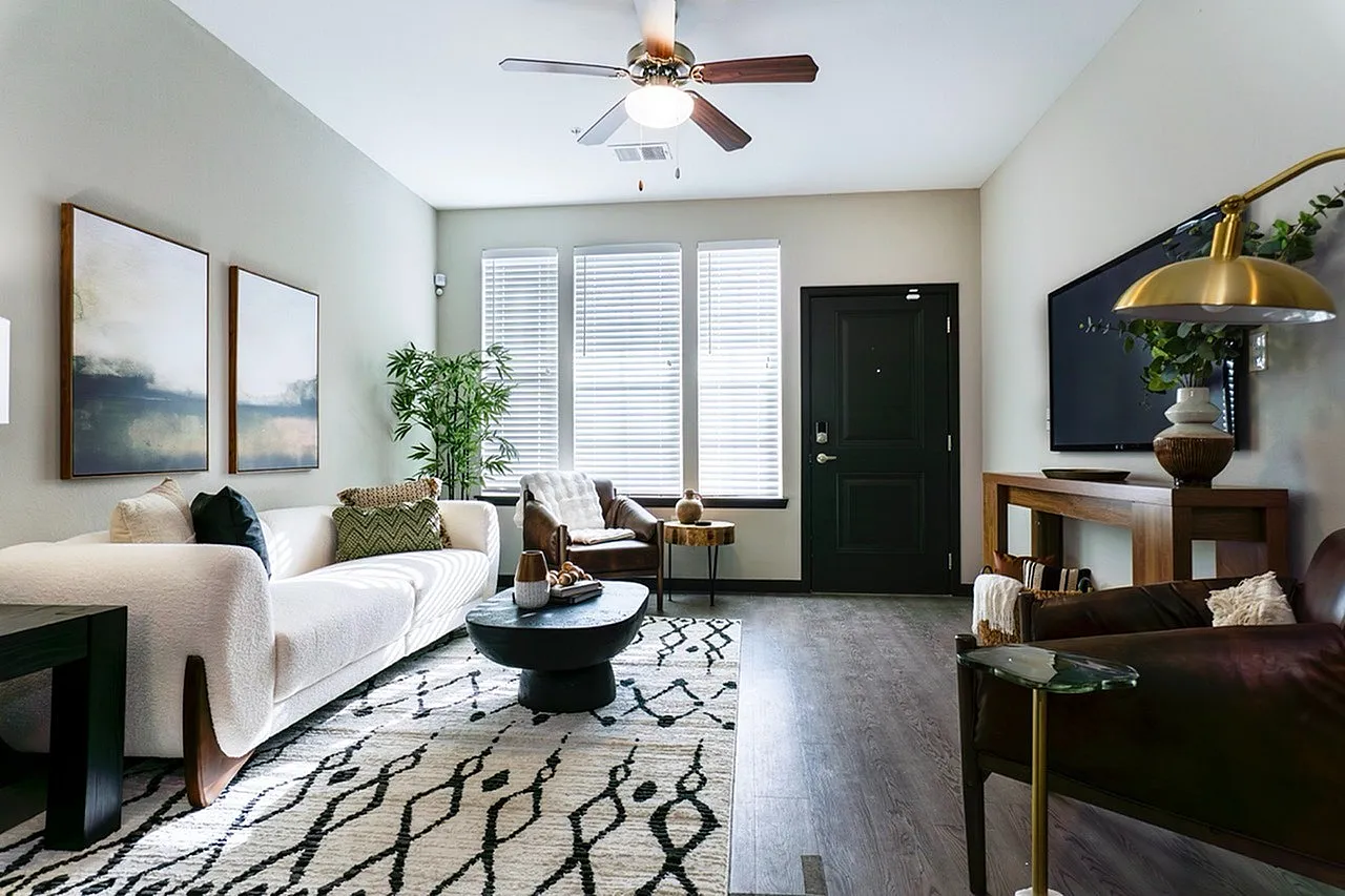 Stylish living room with modern decor, cozy seating, and abundant natural light from large windows.