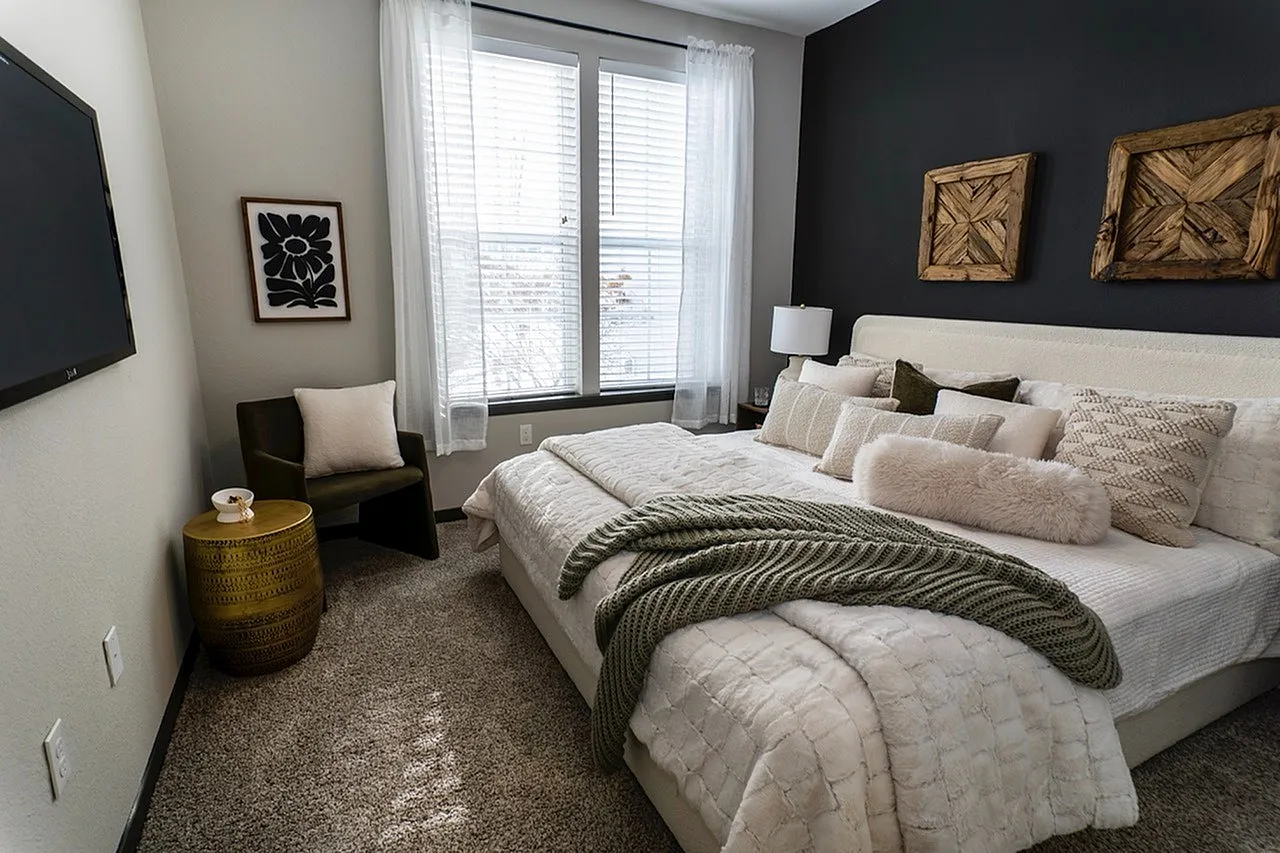Cozy bedroom with elegant decor, plush bed, stylish armchair, and modern accents.