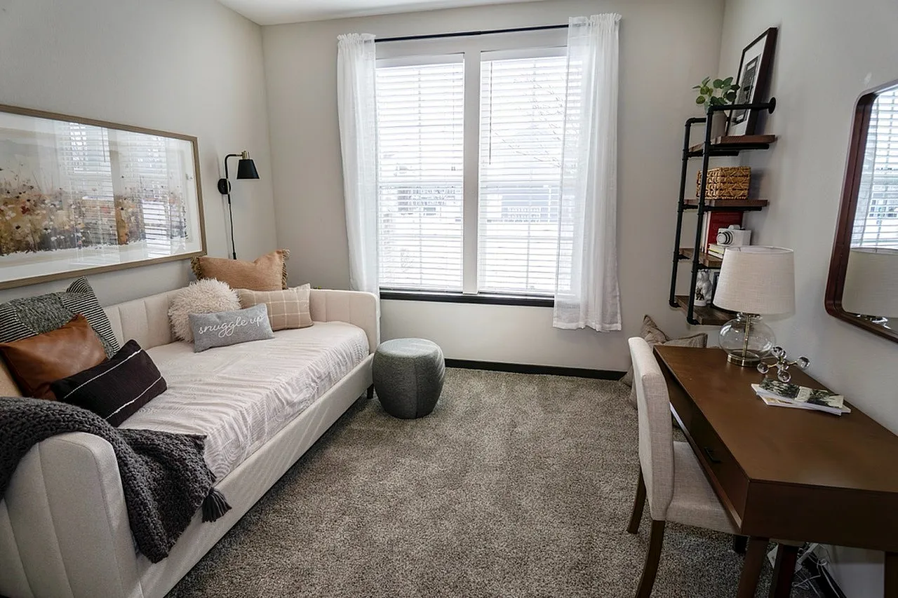 Inviting cozy room with elegant daybed, chic decor, and a bright window creating a serene atmosphere.