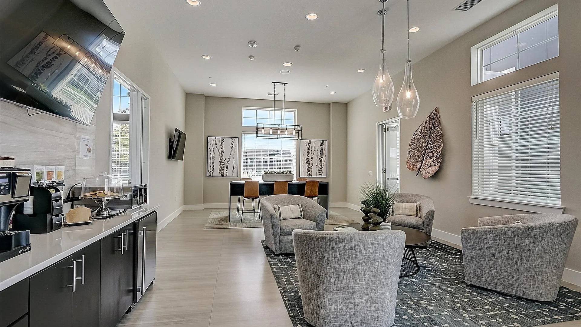 Bright and modern communal space featuring plush seating, stylish decor, and a coffee station. Ideal for relaxation and gatherings.