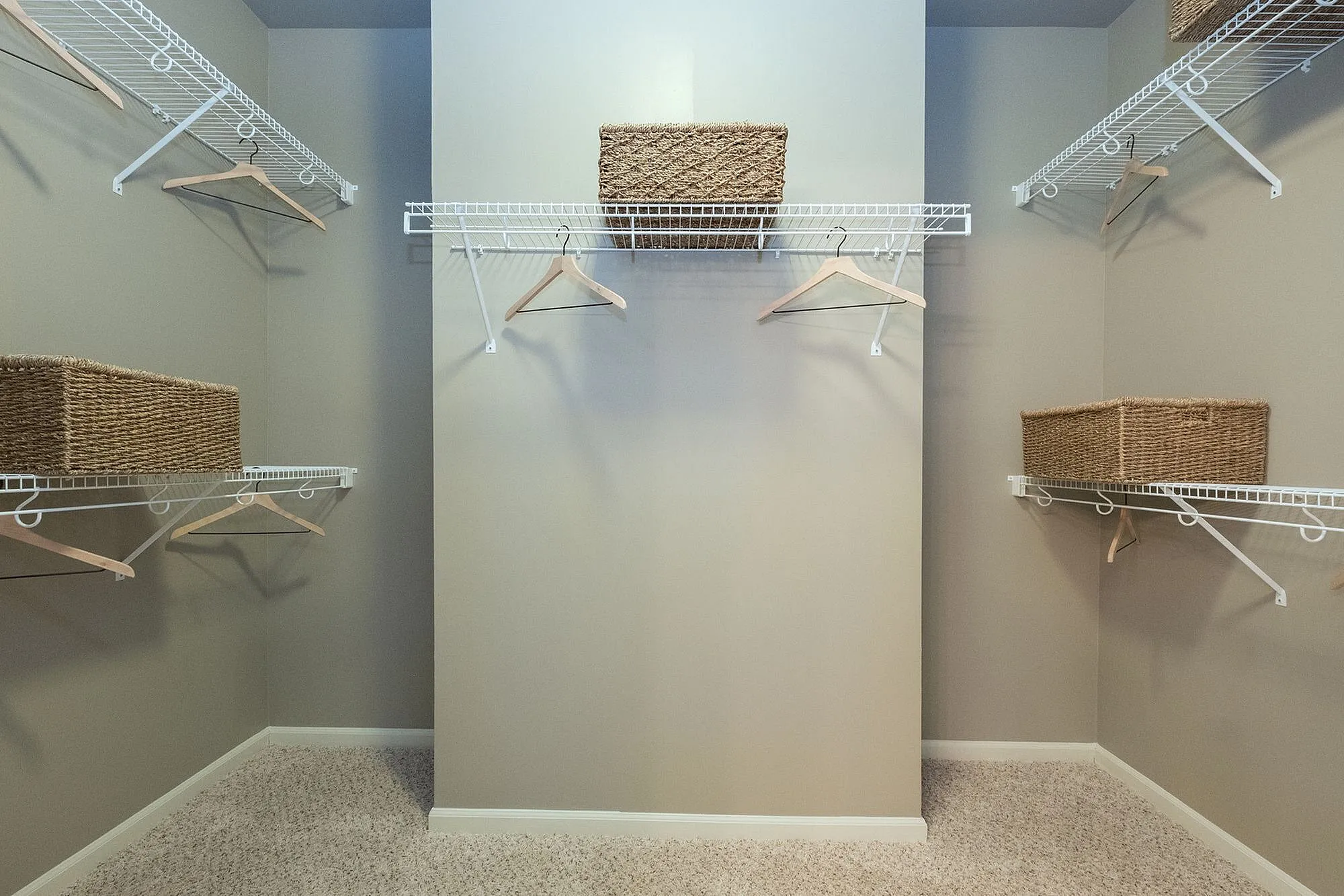 Spacious walk-in closet with sleek wire shelving and elegant woven baskets for organized and stylish storage.
