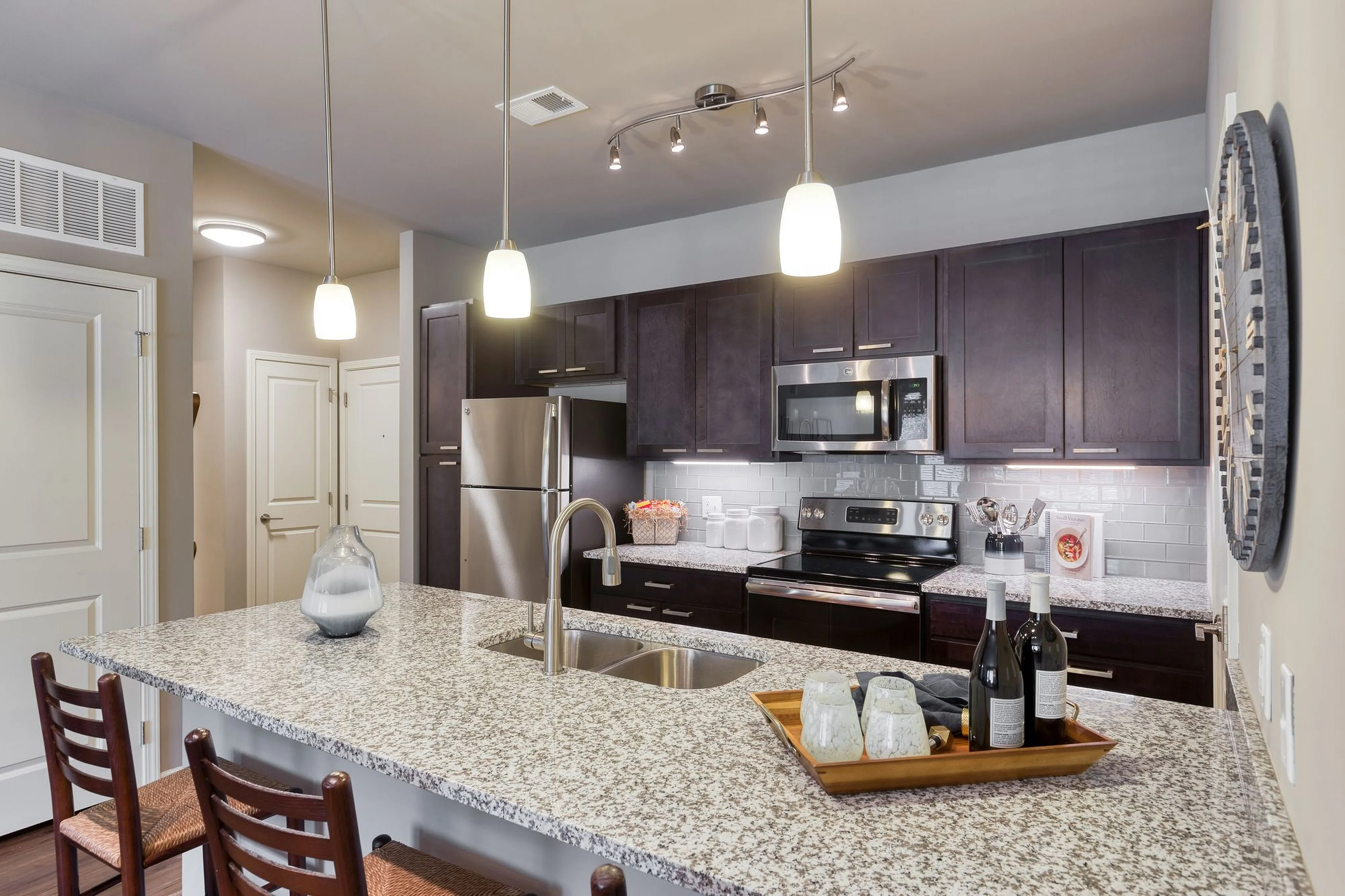 Modern kitchen with sleek dark wood cabinets, stainless steel appliances, and a spacious granite island perfect for entertaining.