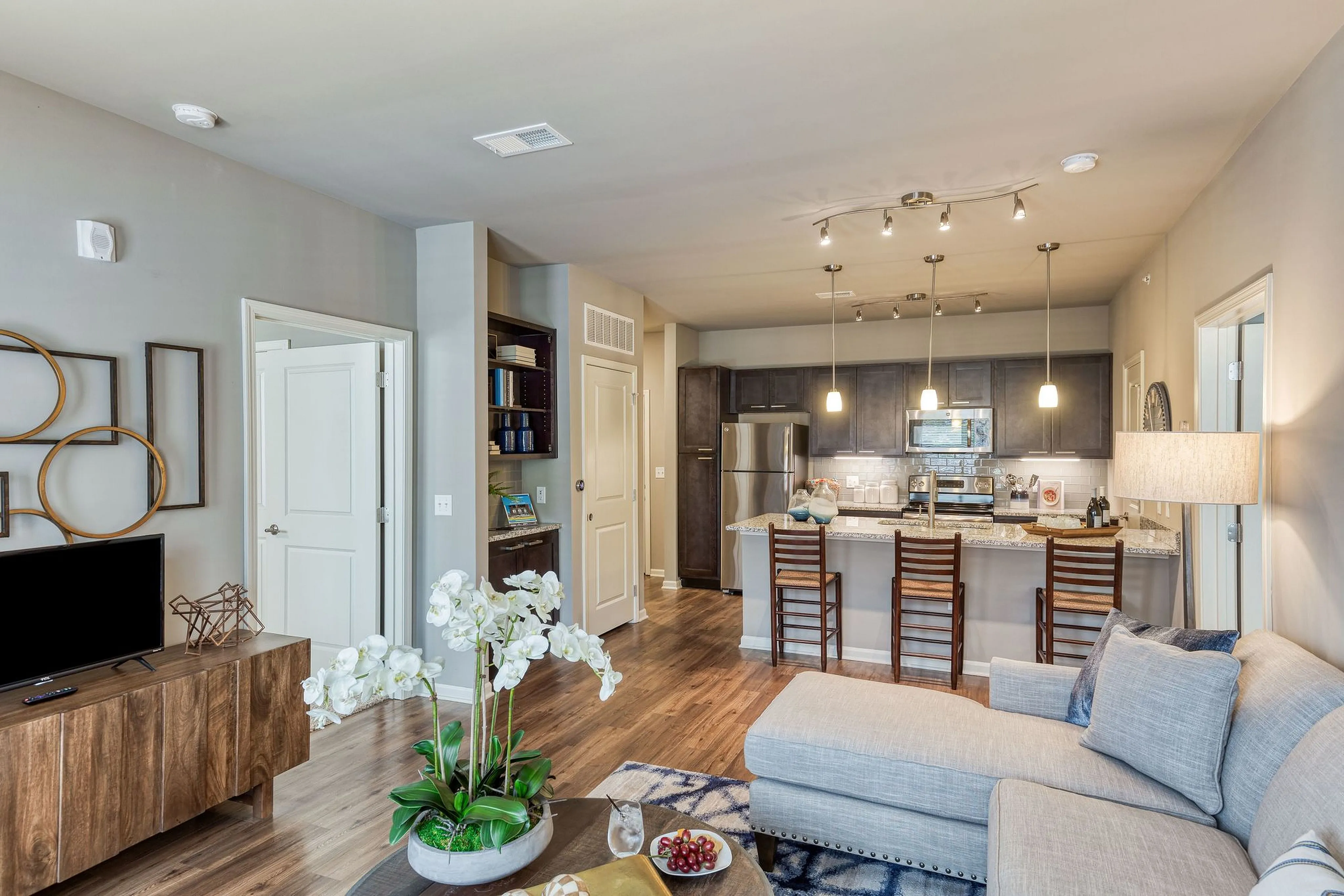 Contemporary open-concept living space with elegant decor, modern kitchen, and cozy seating area featuring beautiful natural lighting.