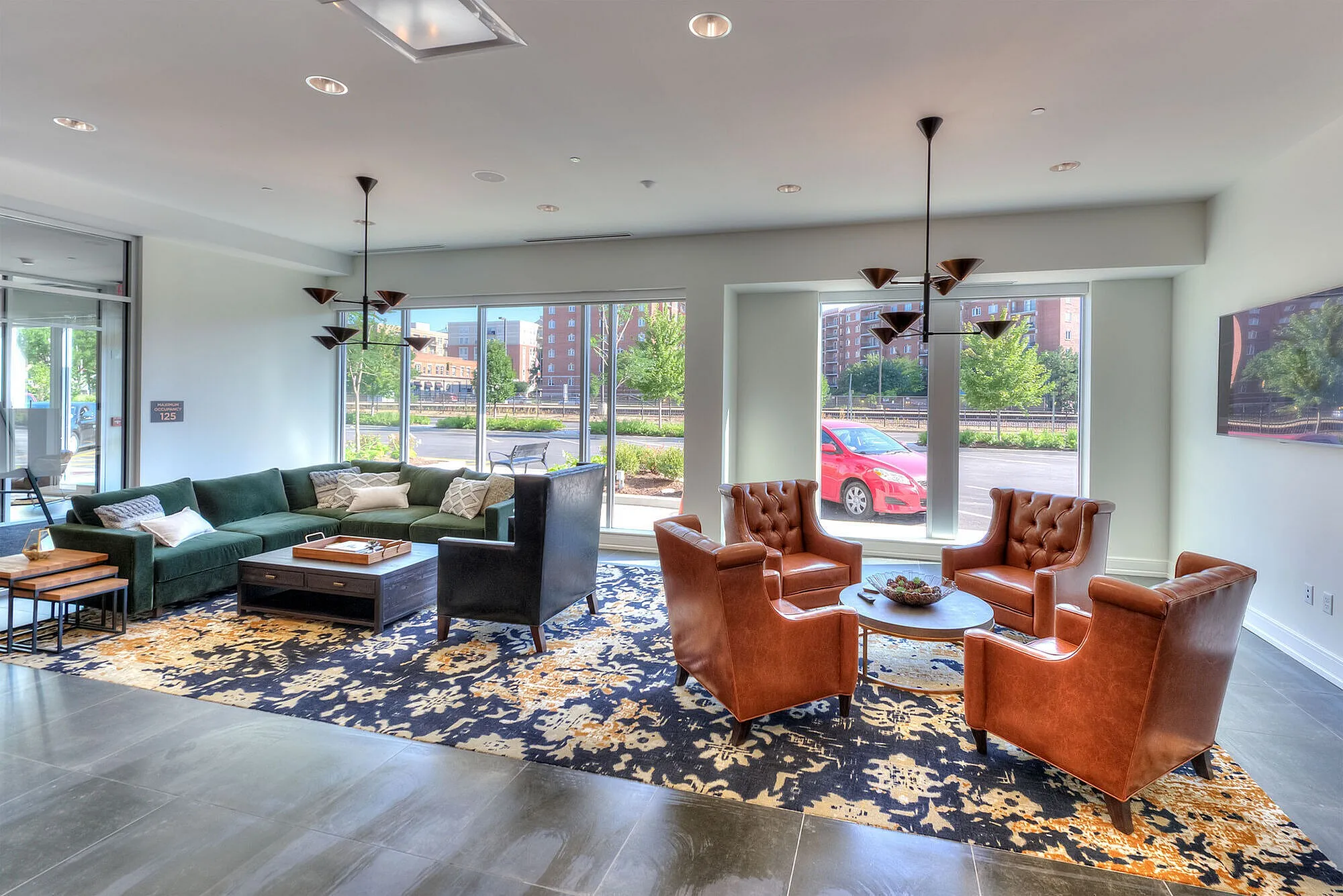 Elegant and spacious living room with plush seating, large windows offering abundant natural light, and modern decor.