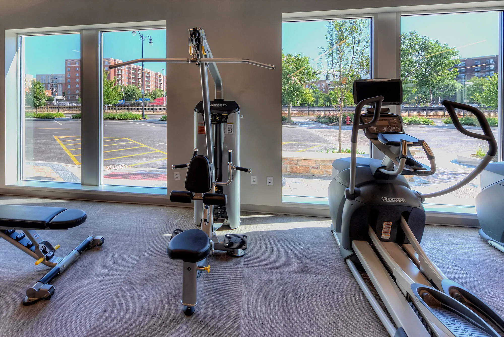 Modern fitness center with state-of-the-art exercise equipment and large windows offering a scenic view.