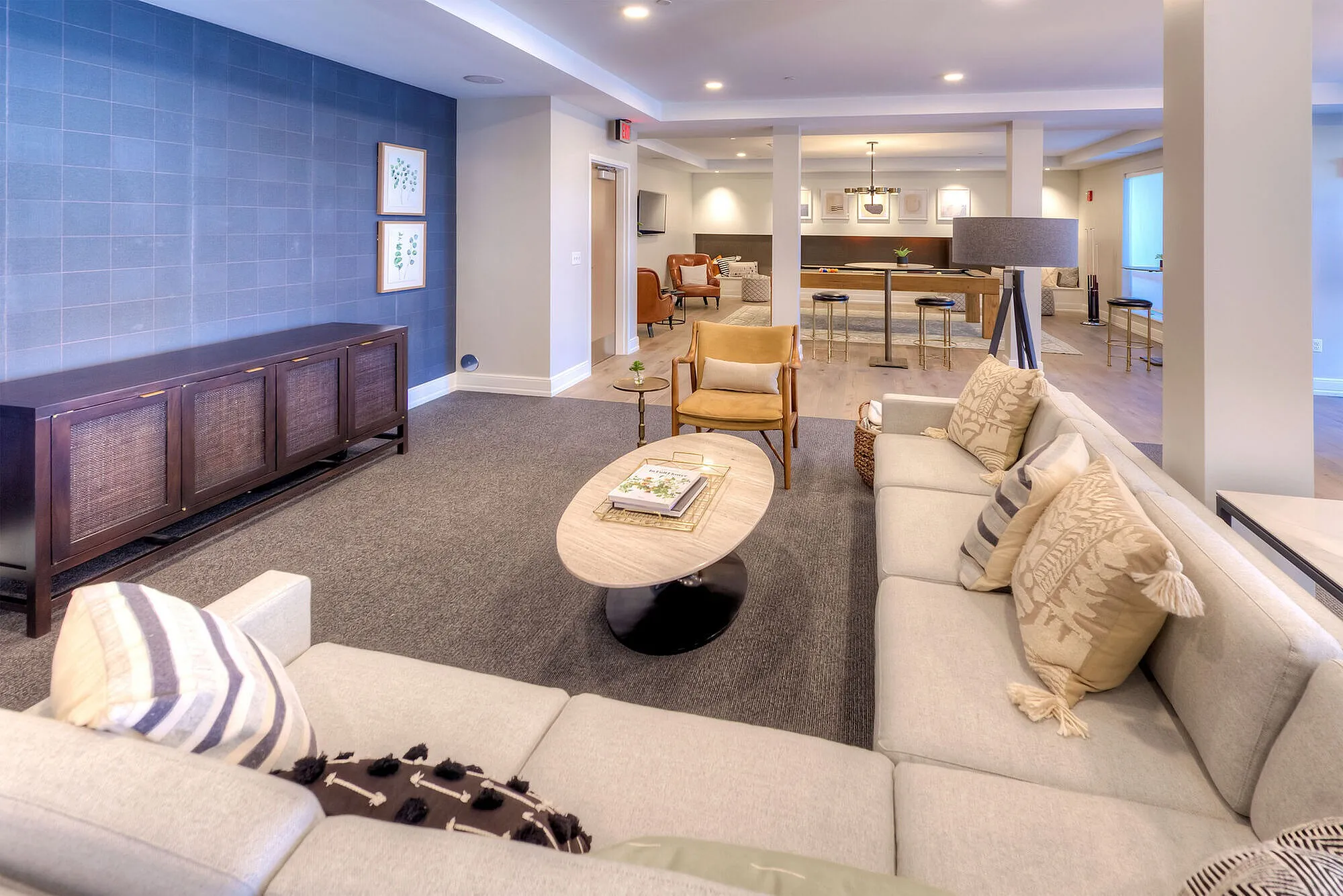 Sophisticated living room with plush sofas, modern decor, and open layout leading to dining area, perfect for entertaining guests.