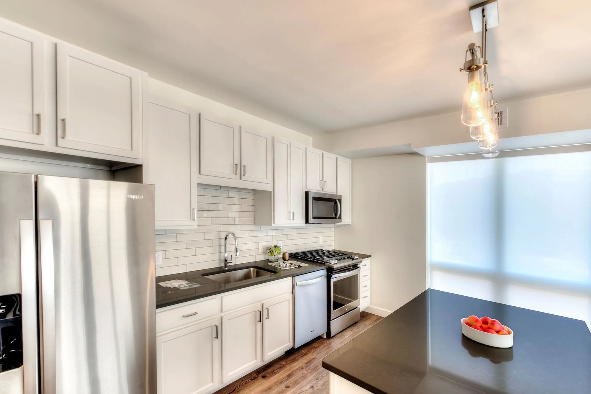 Modern kitchen with sleek stainless steel appliances, chic white cabinets, and cozy lighting, ideal for culinary enthusiasts.