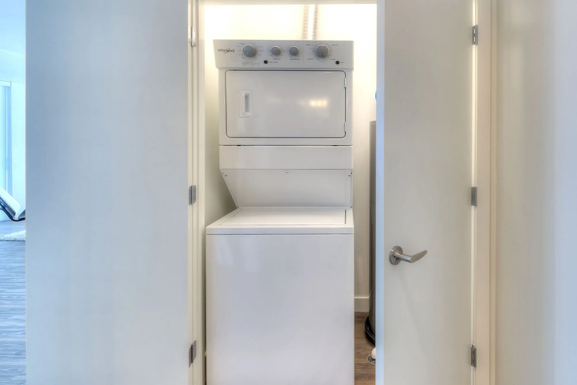 Modern apartment laundry space featuring a sleek, compact stackable washer and dryer unit, efficiently designed for convenience.