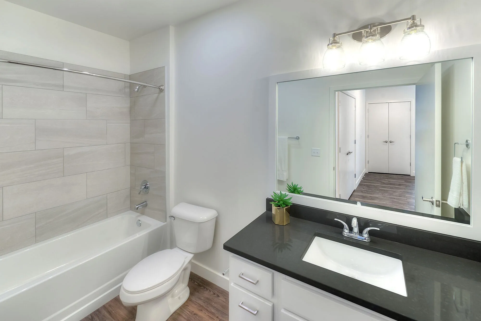 Modern bathroom with sleek fixtures, large mirror, and elegant tile accents, offering a bright and refreshing atmosphere.