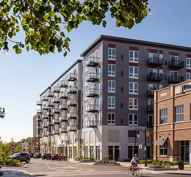 Modern urban apartment complex with stylish balconies and vibrant street view.