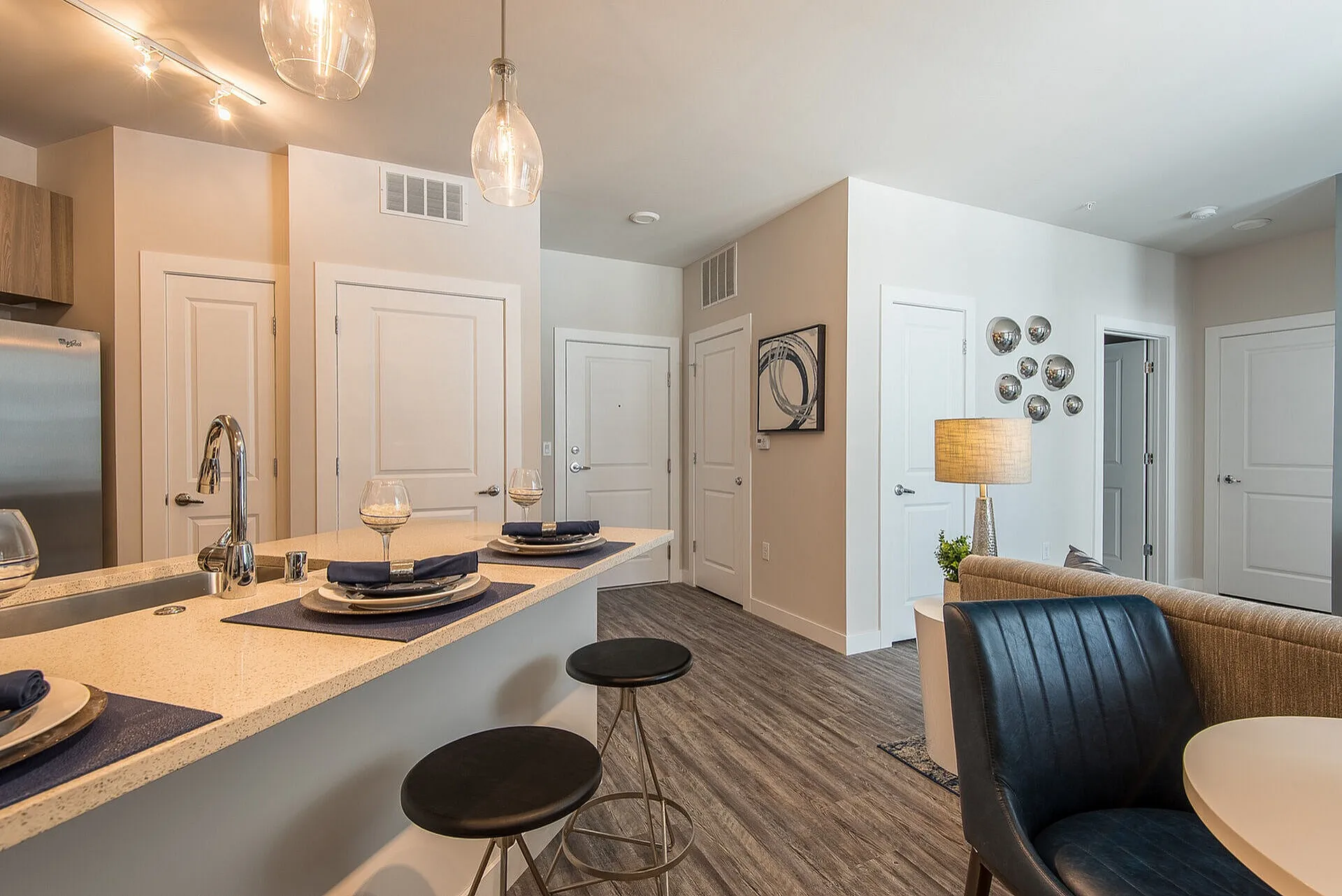 Contemporary open-plan apartment with elegant lighting, sleek kitchen island, and stylish dining area boasting modern decor.