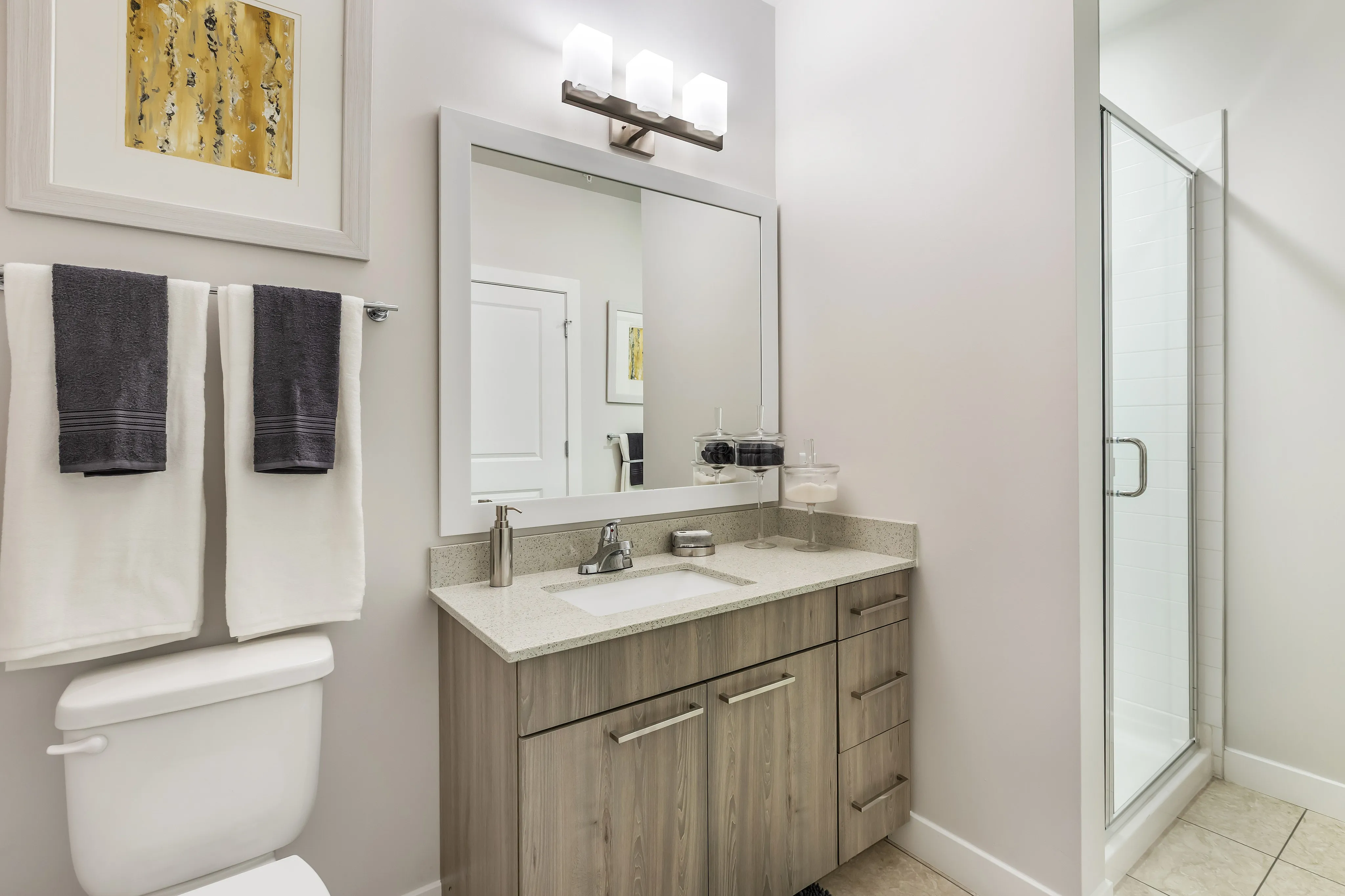 Elegant bathroom with modern fixtures, featuring a spacious shower, sleek vanity with ample storage, and tasteful decor.