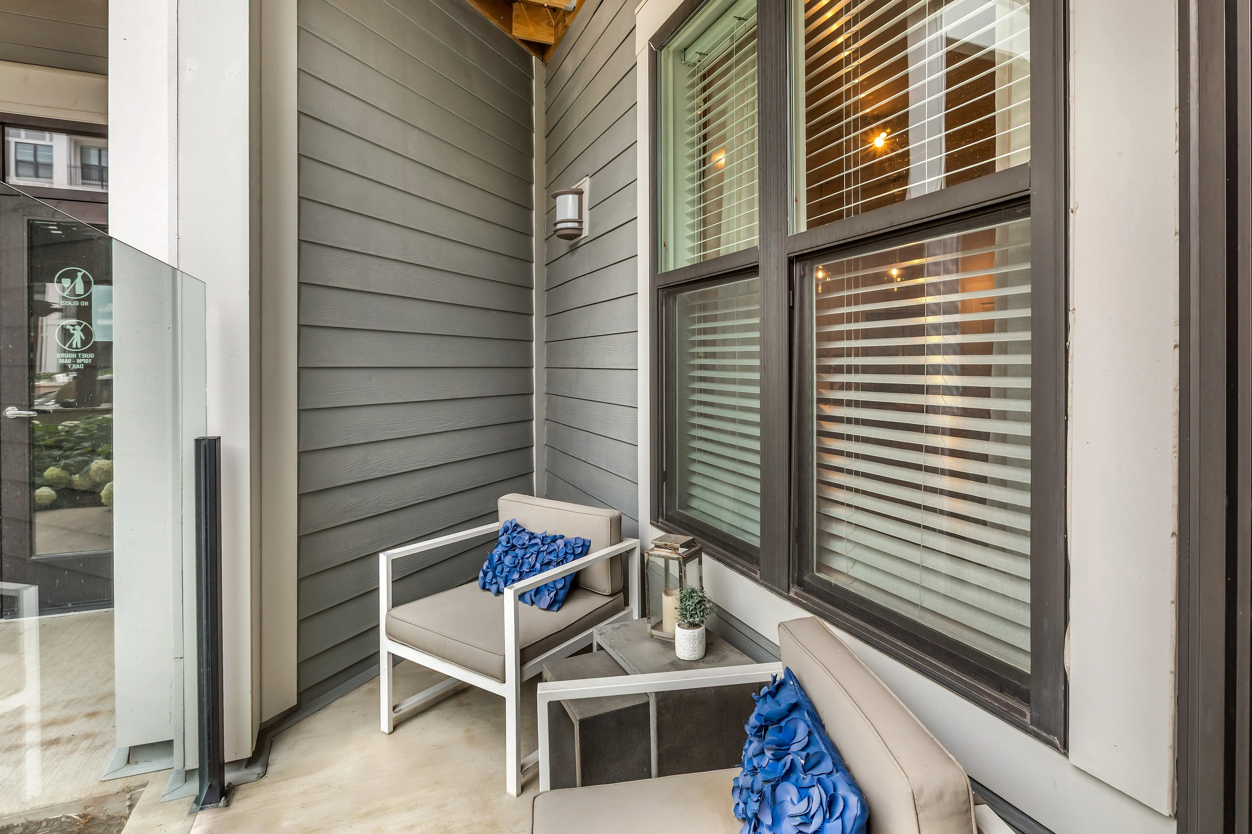 Charming outdoor patio with modern seating, elegant blue cushions, and stylish decor, perfect for relaxation.