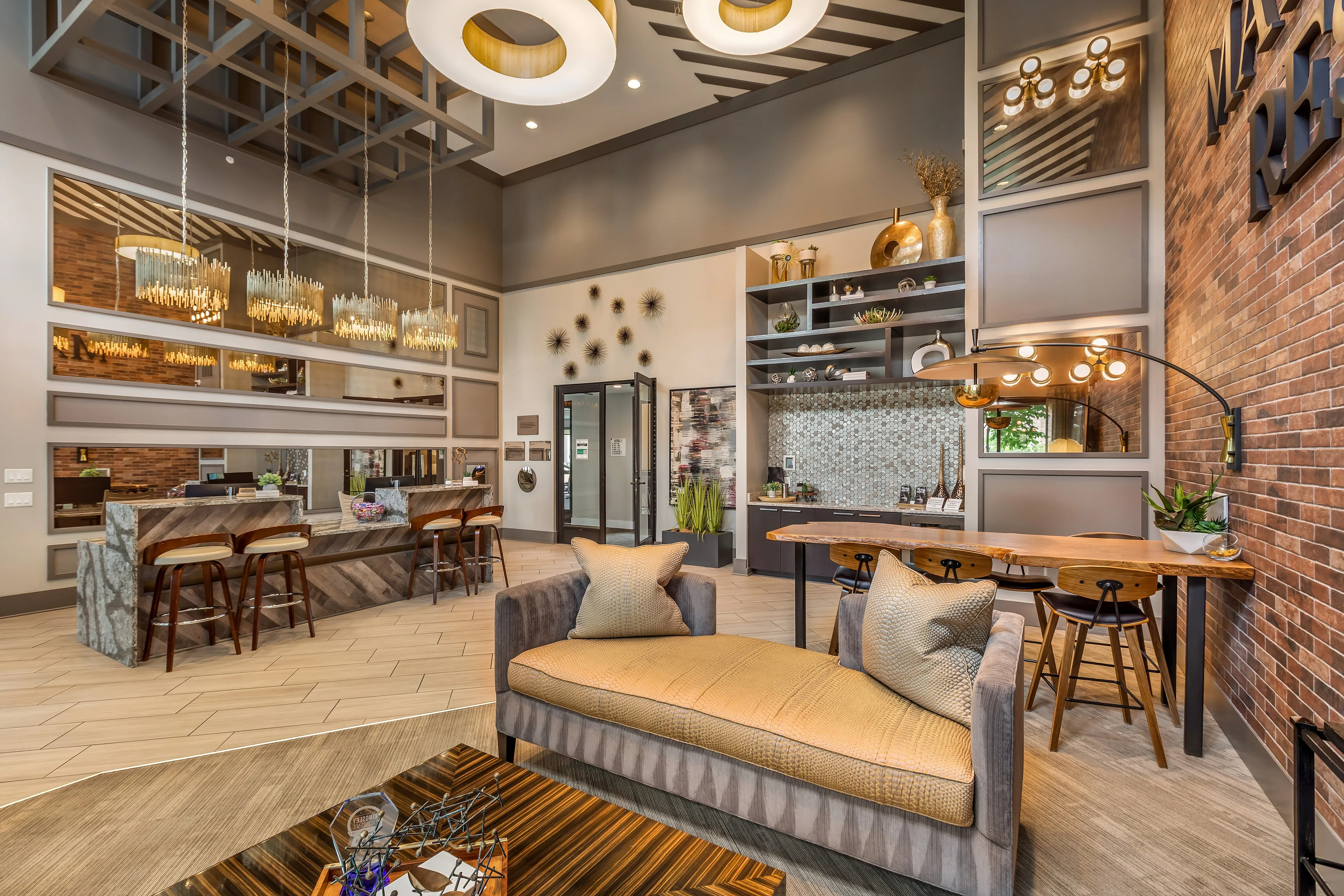 Luxurious modern apartment lobby featuring elegant lighting, cozy seating areas, and a stylish open layout with natural stone accents.