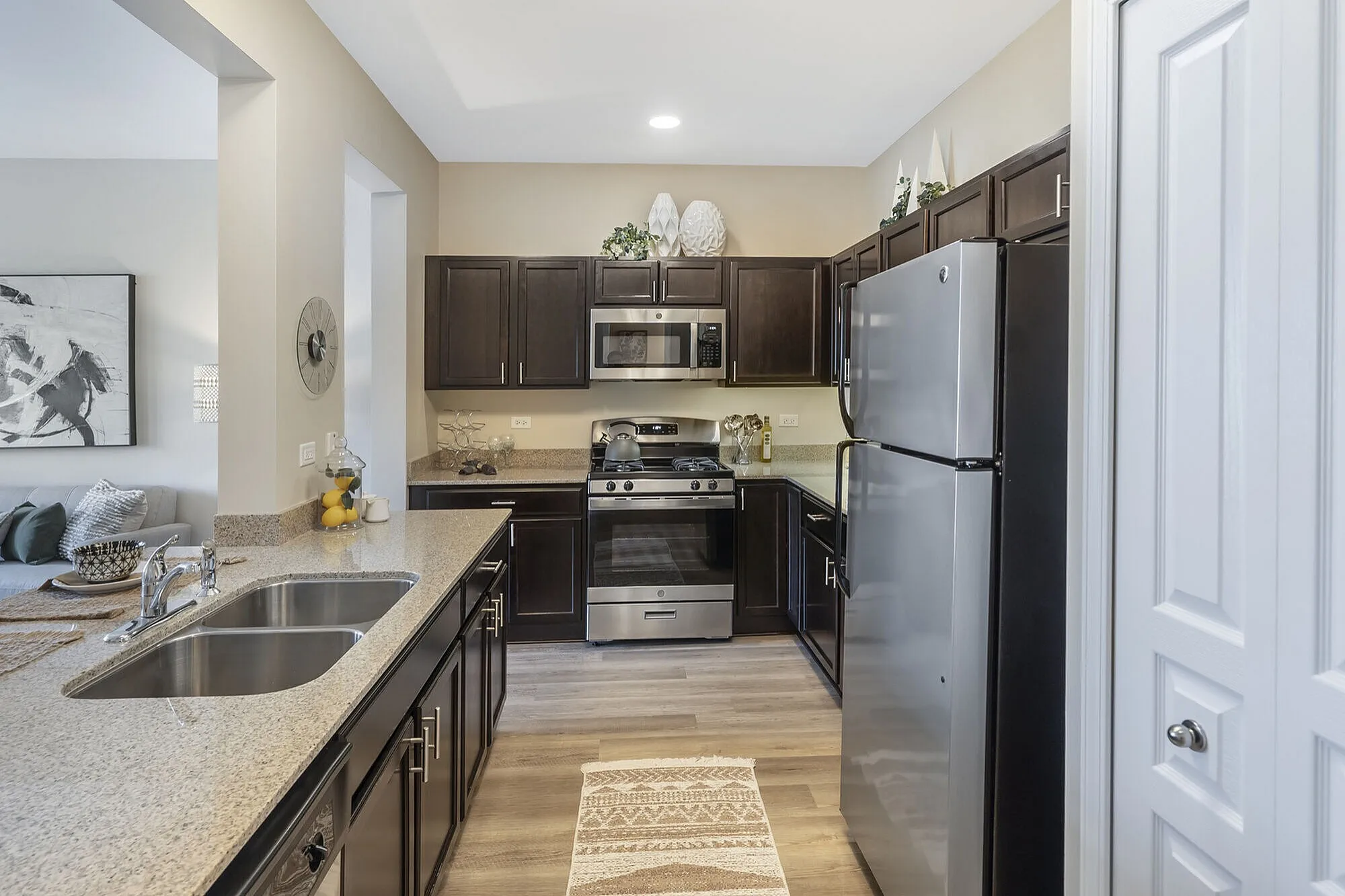 Modern kitchen with sleek stainless steel appliances, elegant dark cabinetry, and a stylish open-plan design.