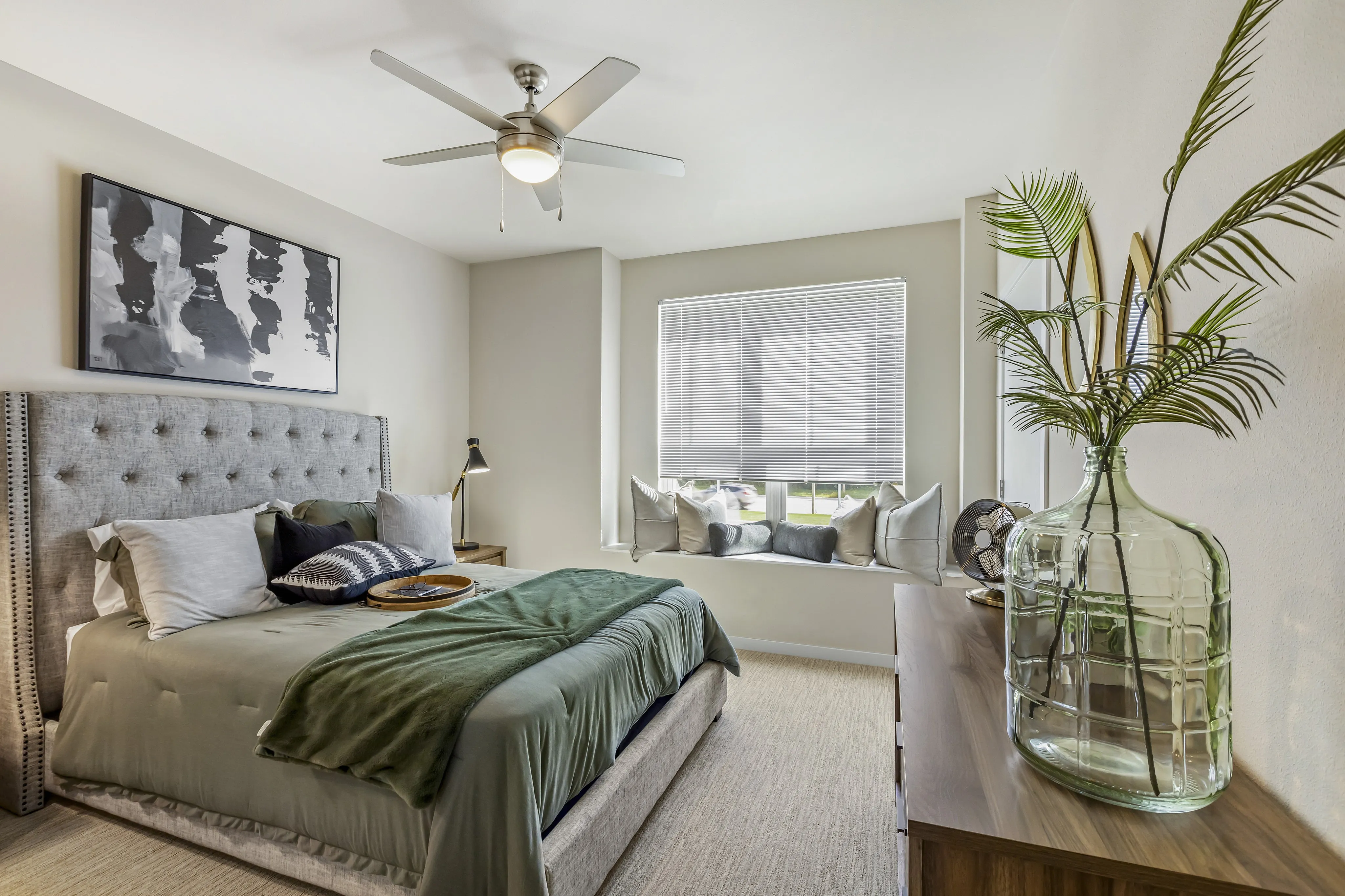 Elegant bedroom with a plush bed, stylish decor, and a cozy window seating area, offering a tranquil retreat filled with natural light.