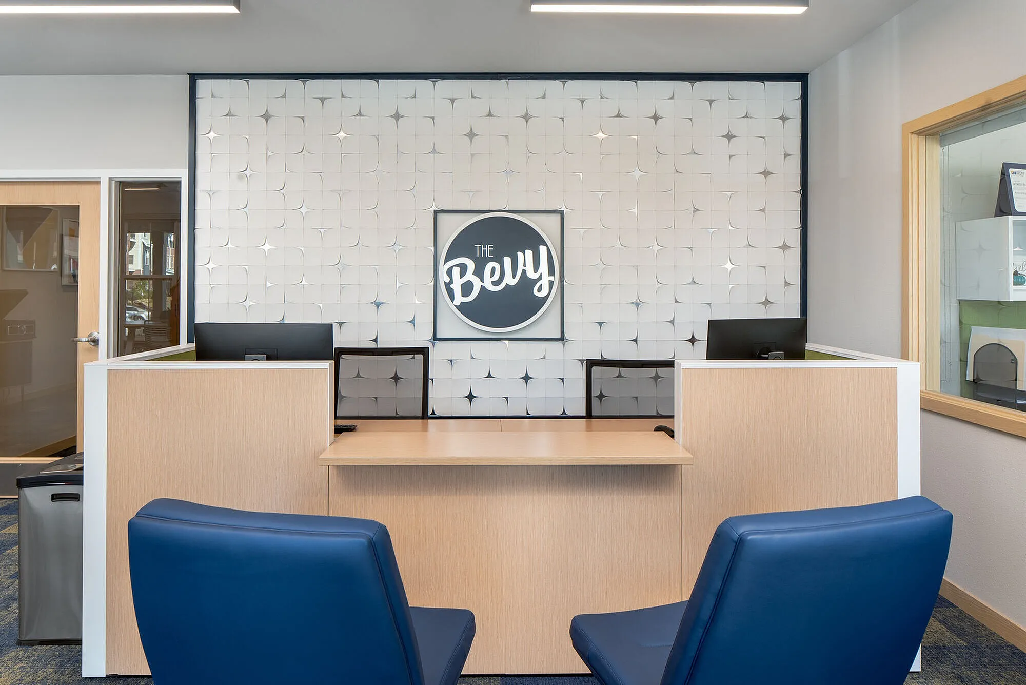 Modern and inviting apartment lobby featuring stylish seating and chic wall design under soft lighting.