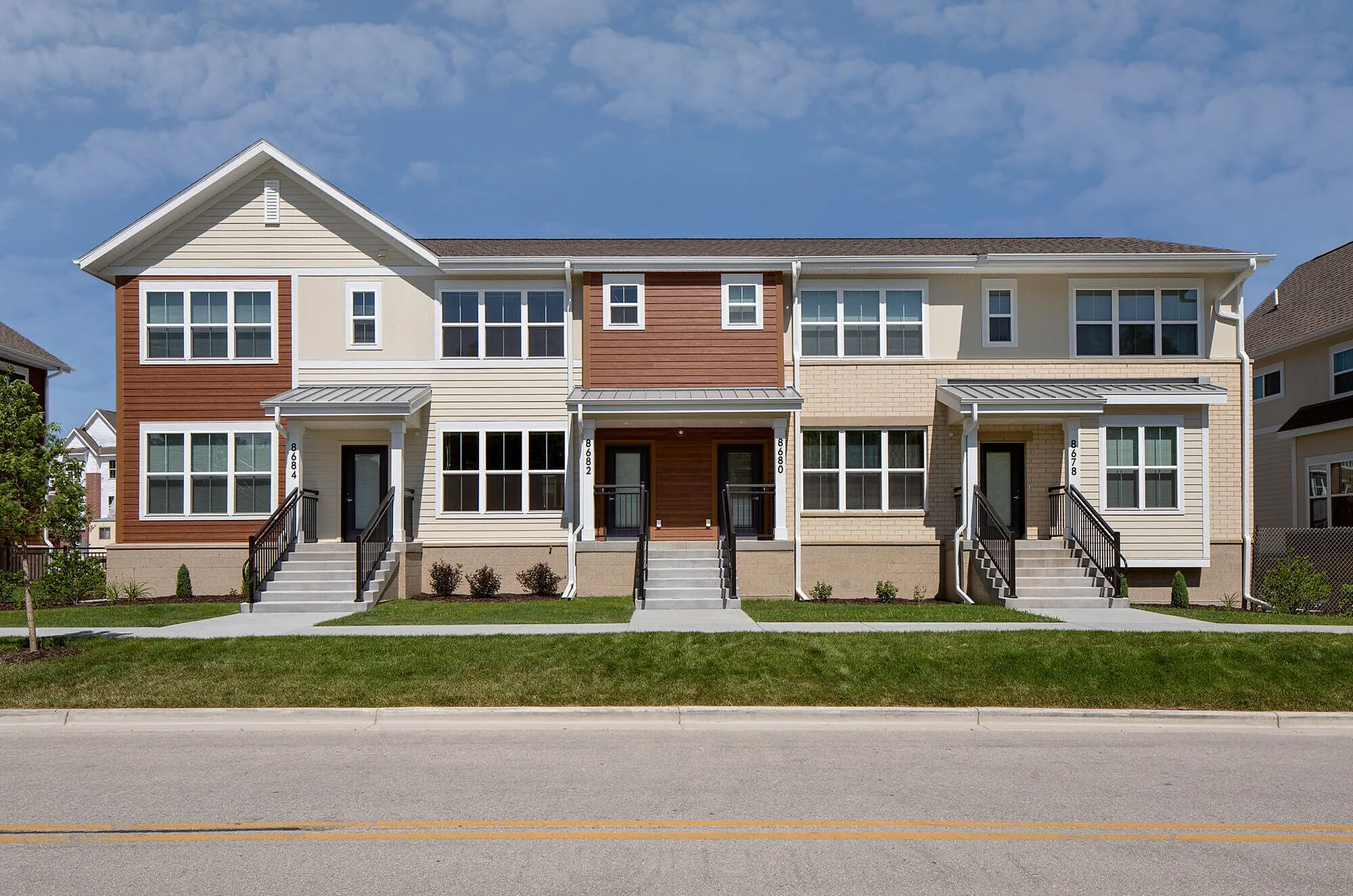 Charming townhouse exterior with modern design, featuring large windows and inviting entryways.