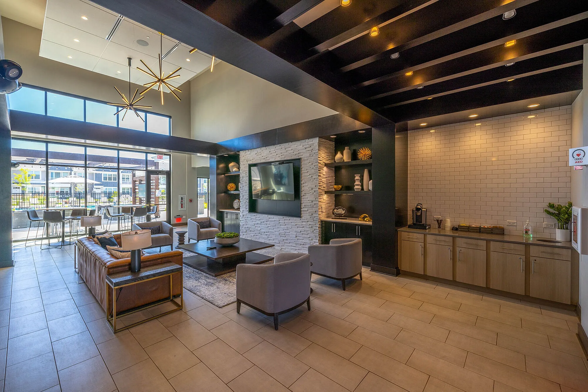 Modern lounge area with sleek furniture, large windows, and stylish lighting, perfect for relaxation and social gatherings.