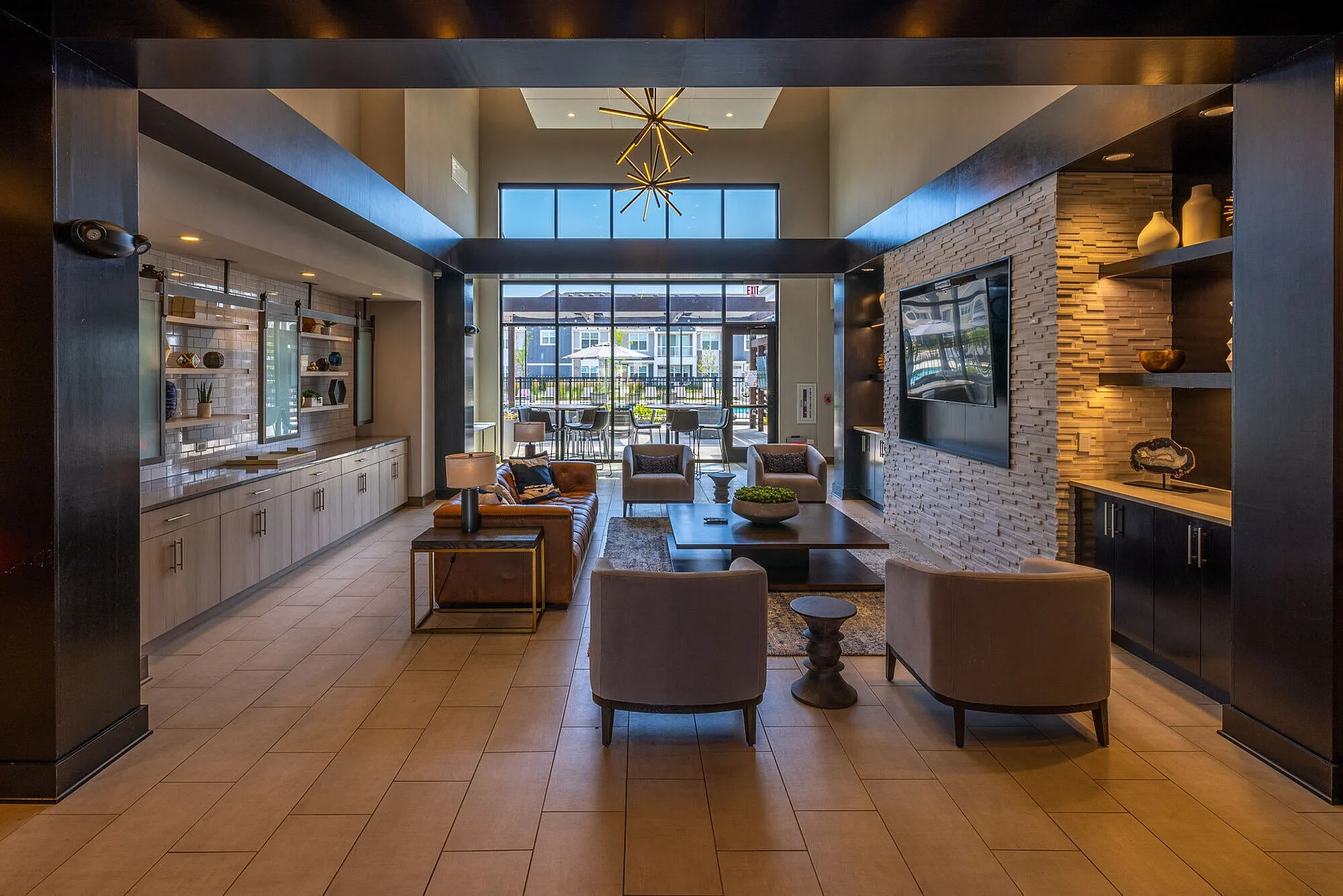 Luxurious modern lobby featuring elegant furniture, stylish decor, and large windows with a view of outdoor seating.