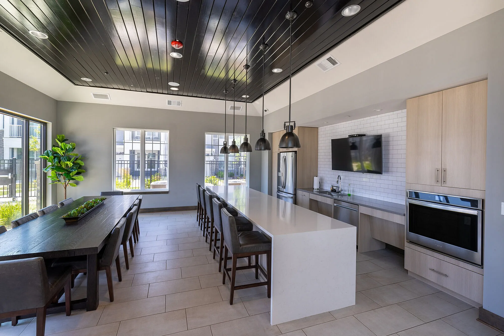 Spacious modern kitchen with elegant white island, stylish pendant lighting, and adjacent dining area perfect for entertaining.