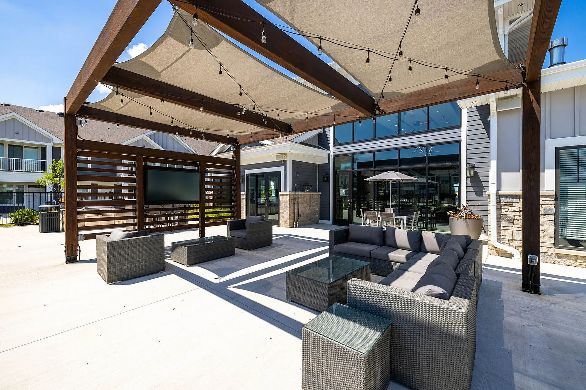 Chic outdoor seating area with stylish sofa sets and modern pergola, perfect for cozy gatherings.