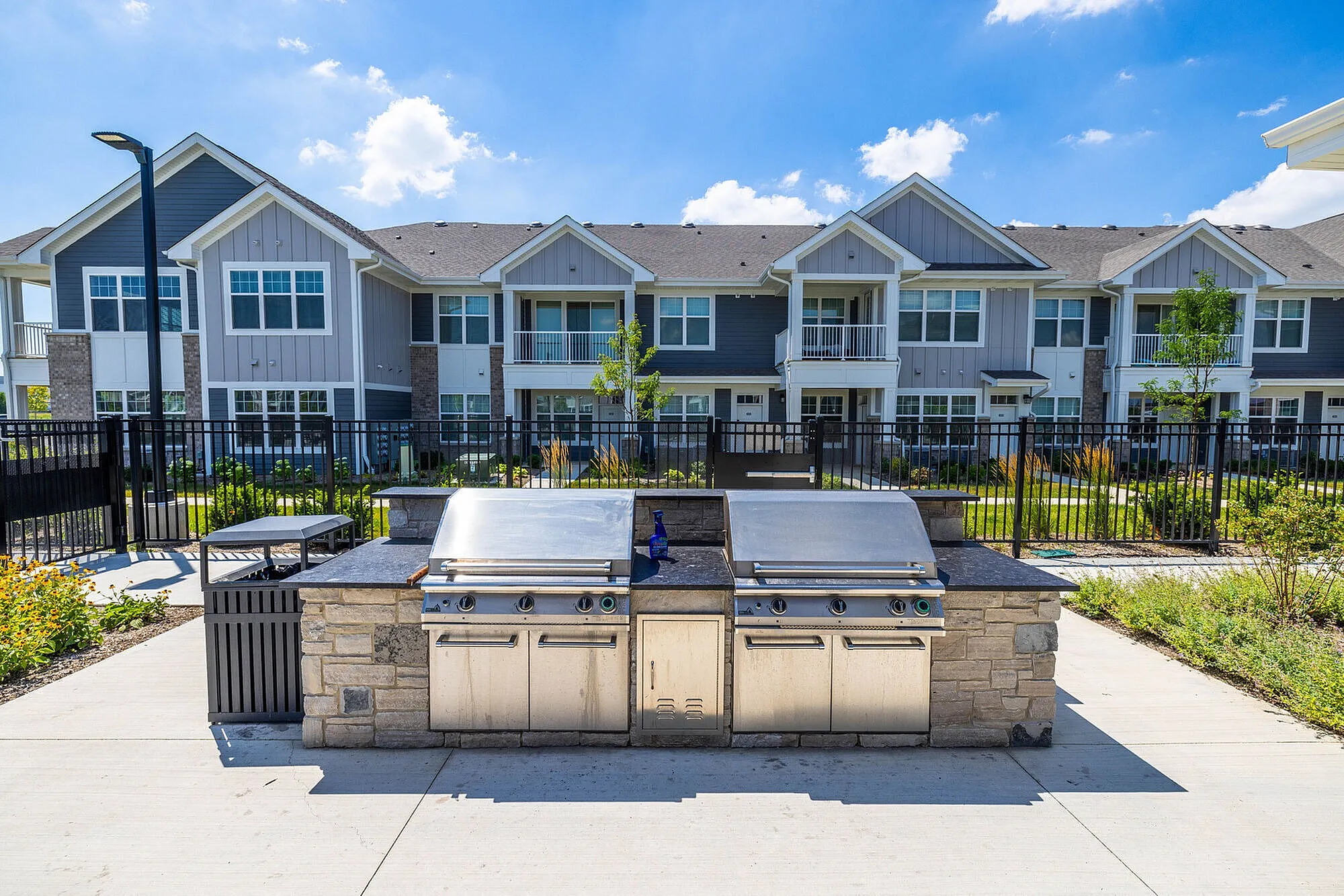 Modern apartment complex boasting beautiful outdoor grill area, perfect for entertaining and summer gatherings.