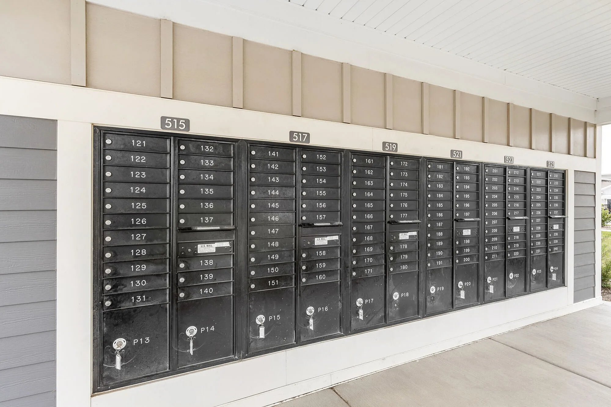 Contemporary apartment mailroom with sleek, organized mailbox units under a sheltered area.