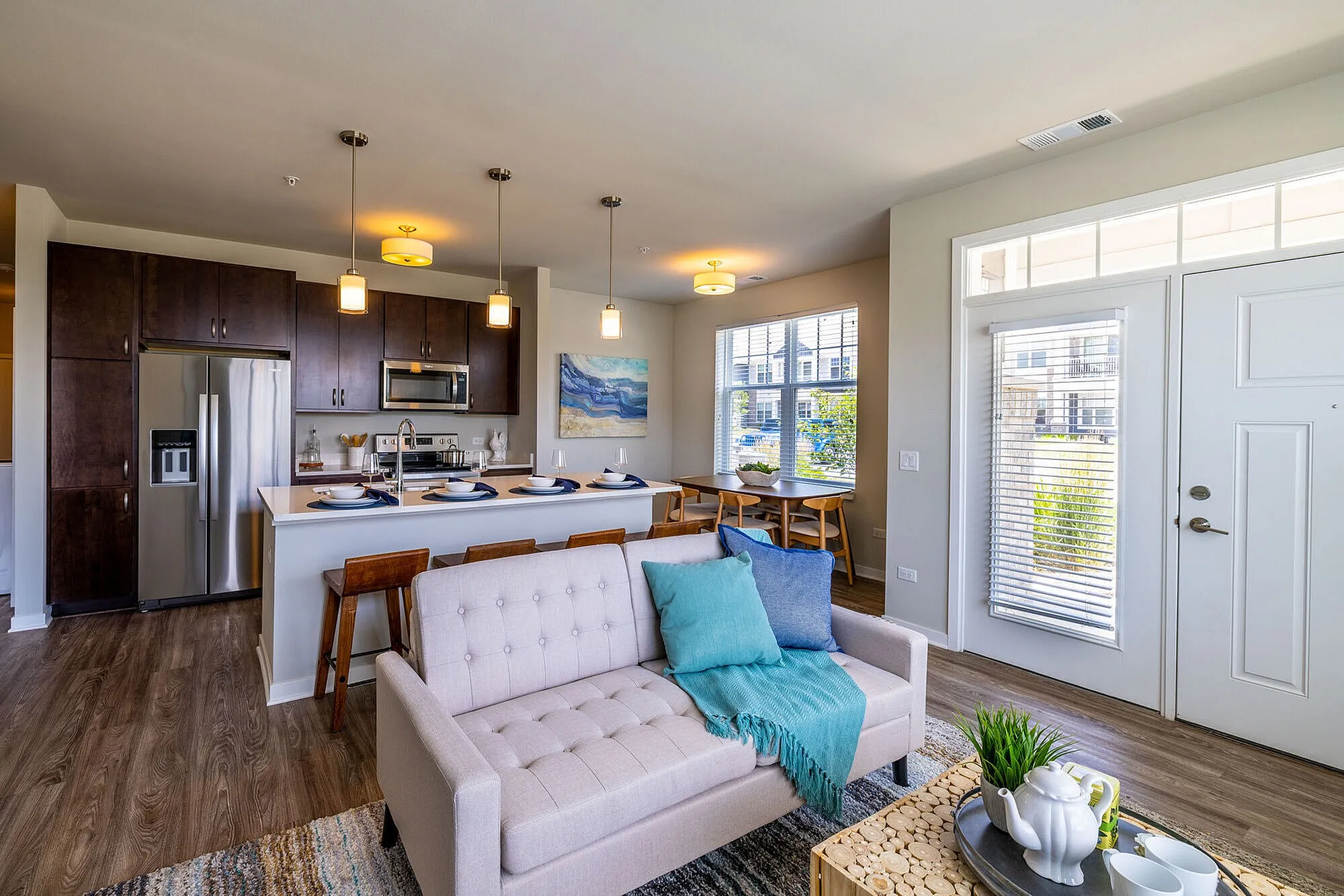 Modern open-concept living area featuring sleek kitchen with stainless steel appliances, cozy seating, and natural light.