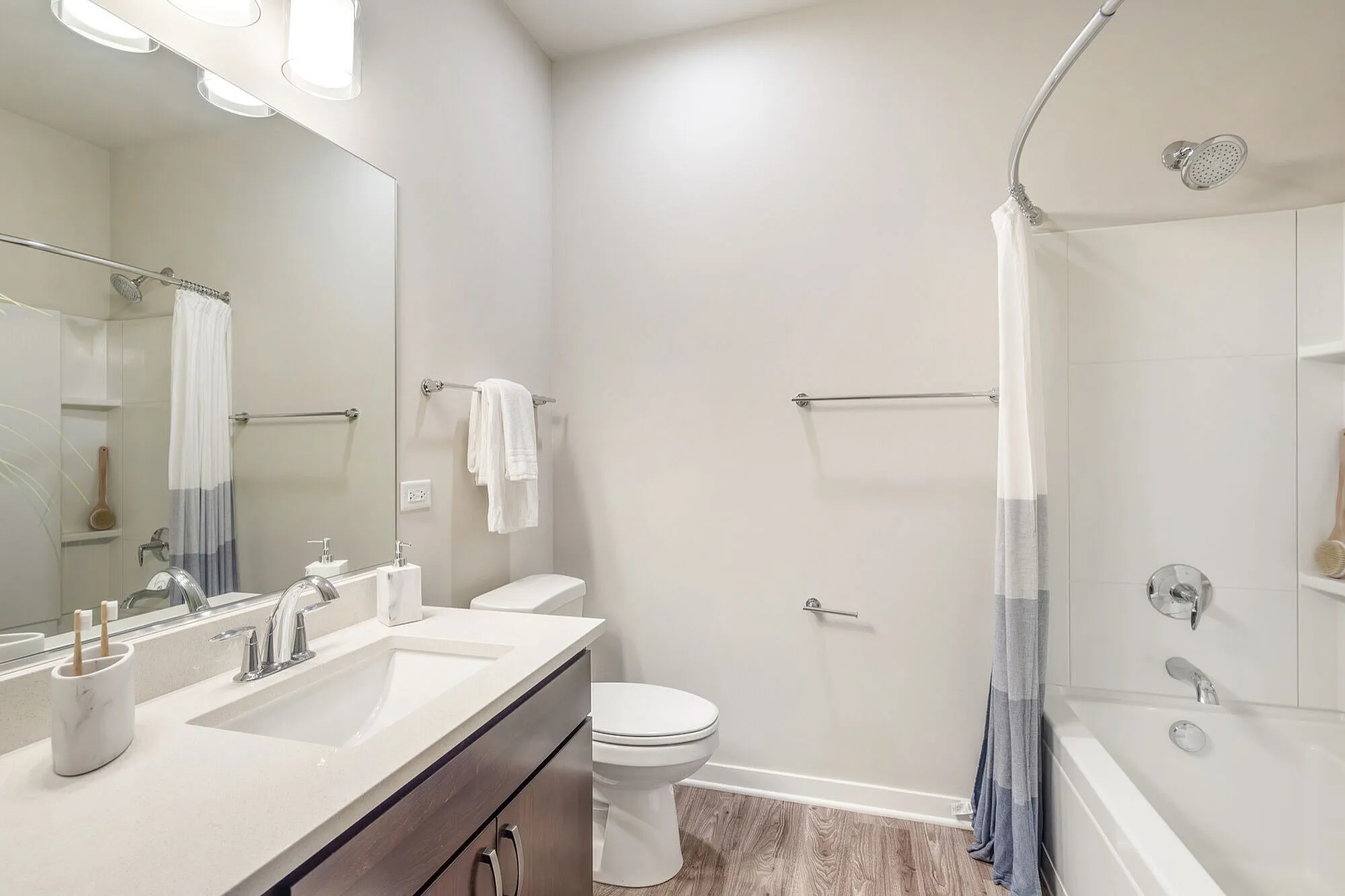 Elegant bathroom with modern fixtures, featuring a spacious vanity, pristine bathtub, and luxurious lighting.