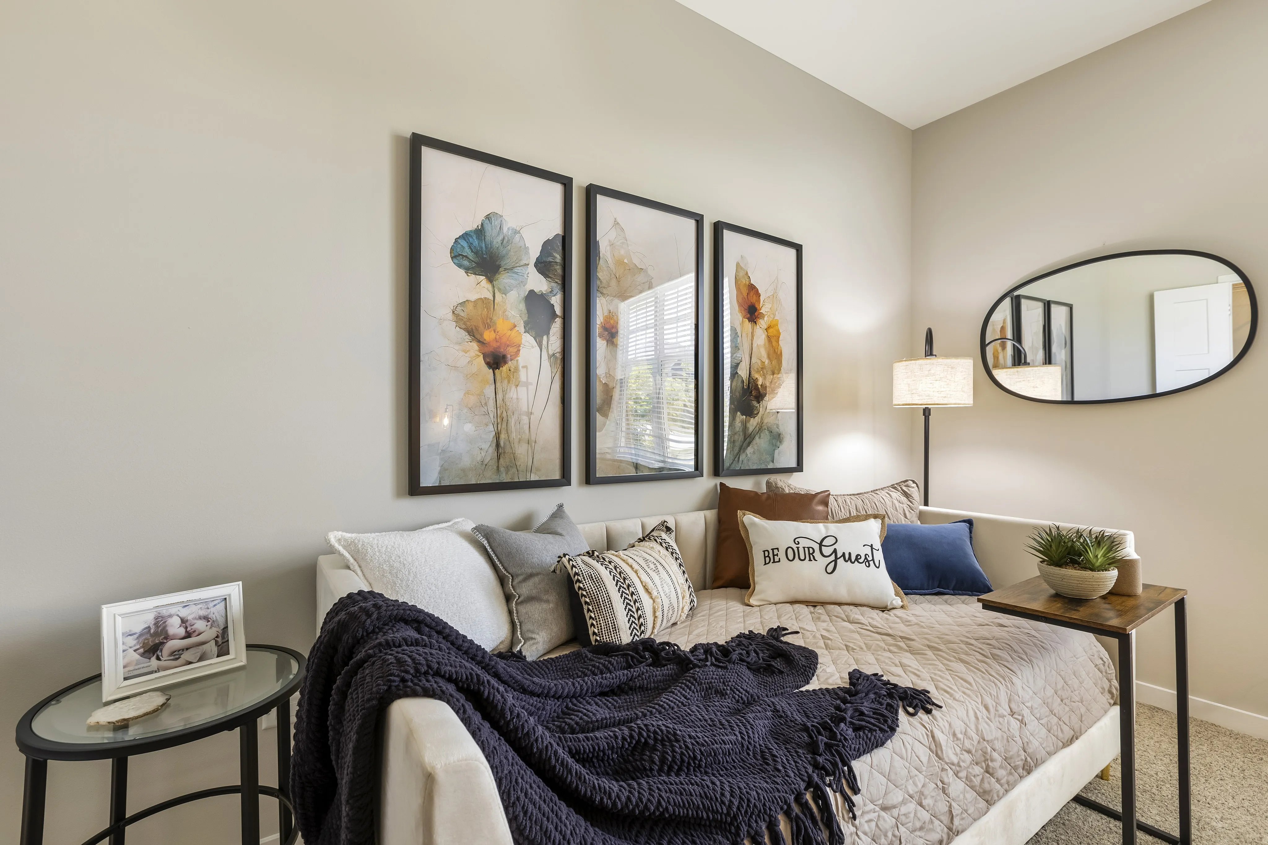 Cozy bedroom with elegant bedding, vibrant floral artwork, and stylish decor, offering a welcoming ambiance.
