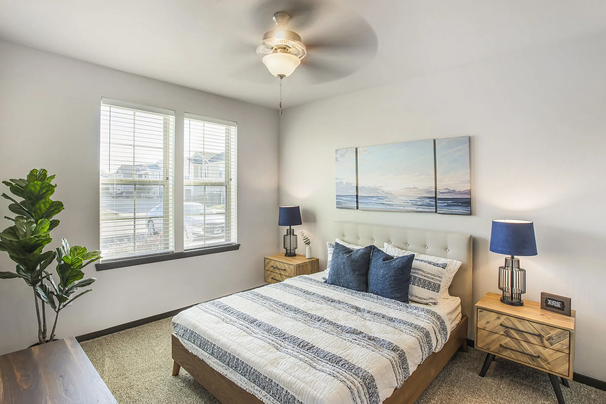 Inviting bedroom with large windows, elegant decor, and warm natural lighting, creating a serene retreat atmosphere.